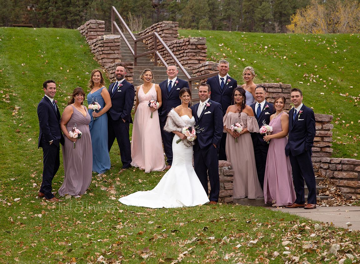 large wedding party with bride and groom in a green park