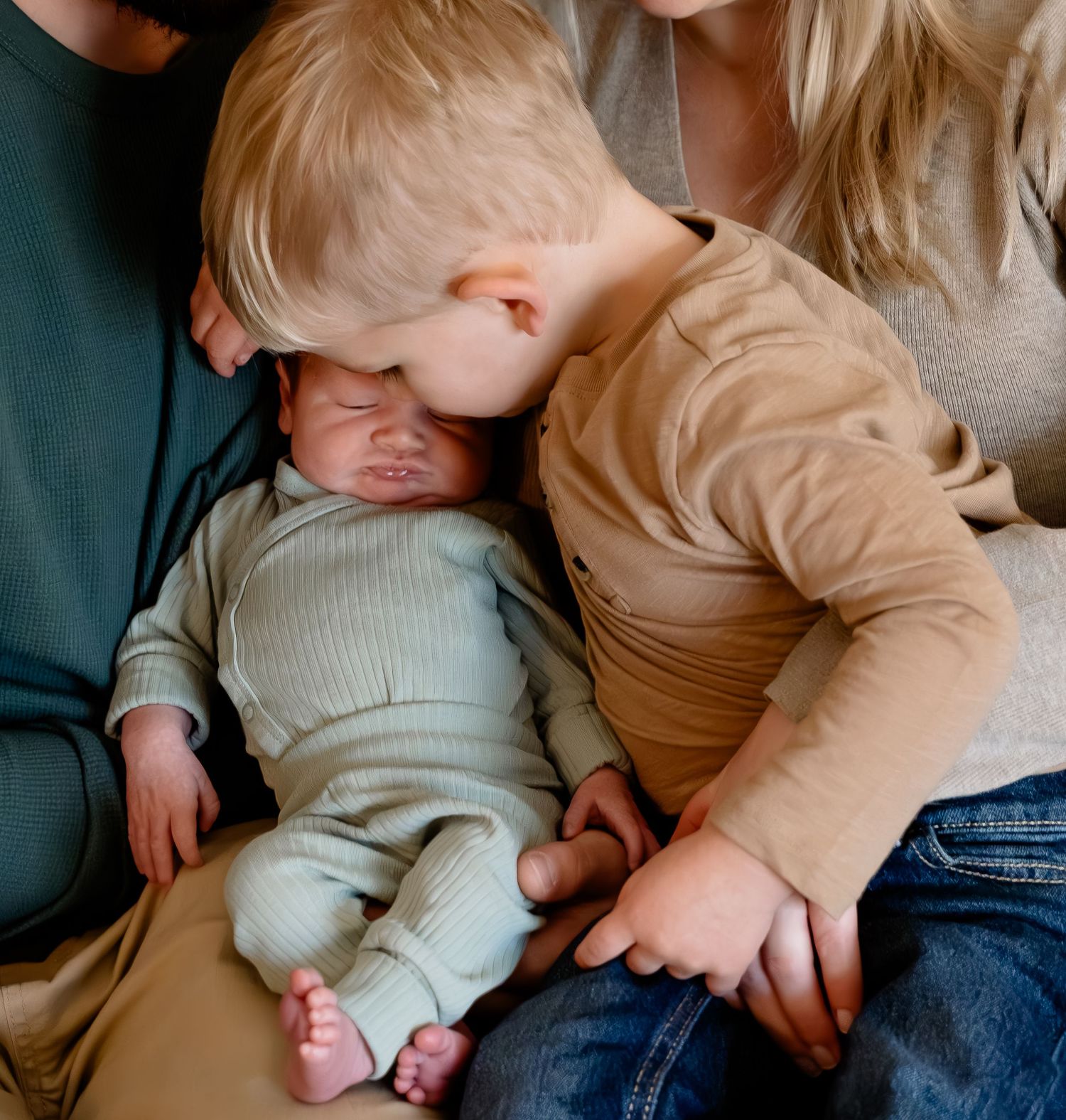Intimate family moment showing gentle interaction in soft neutral tones.