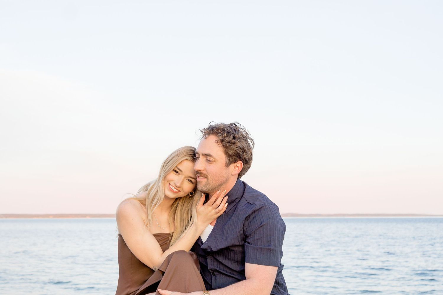 Intimate beach photoshoot with couple sharing tender moments by the ocean.