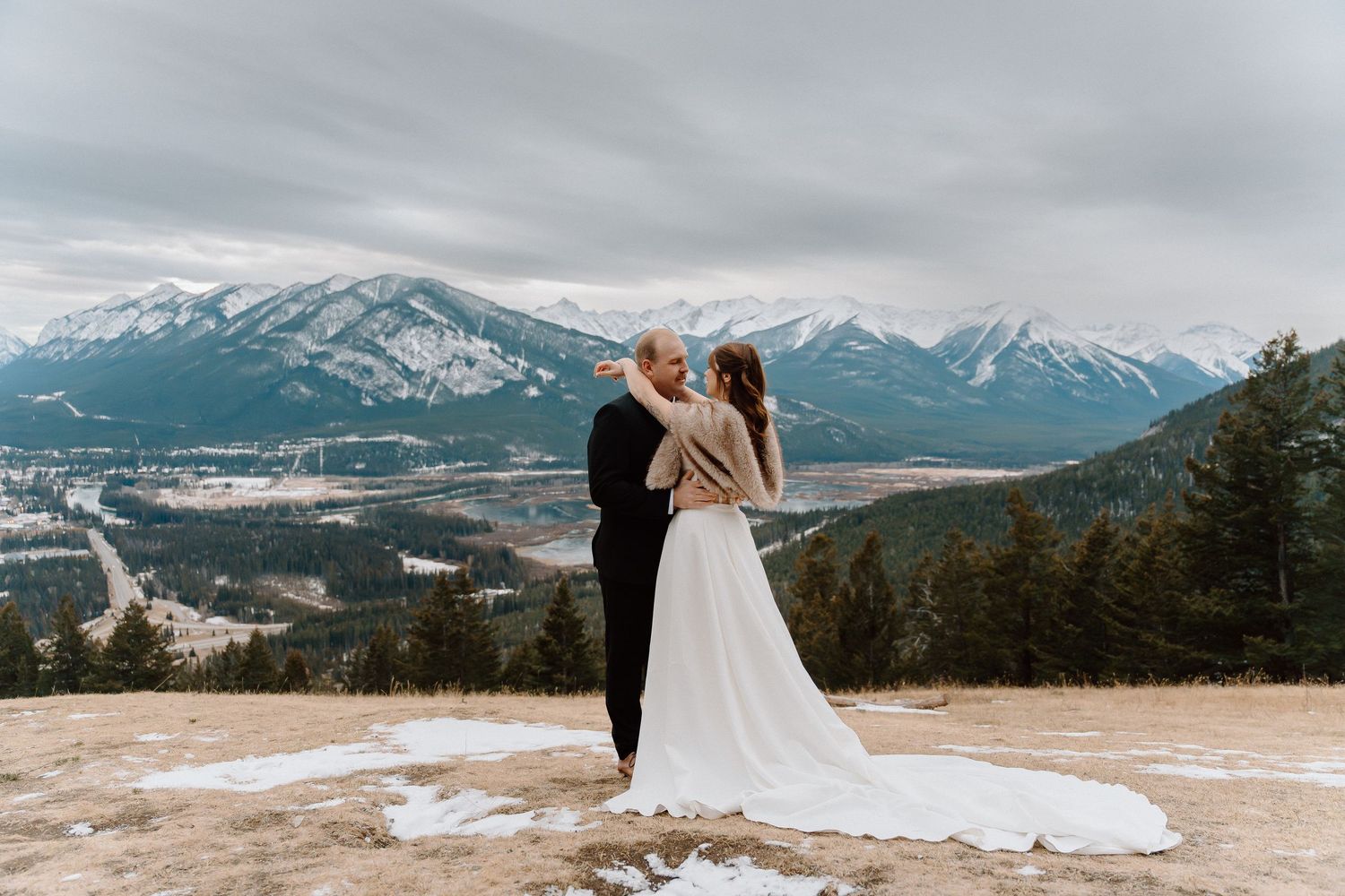Wedding photography session on mountain overlook with dramatic landscape views.