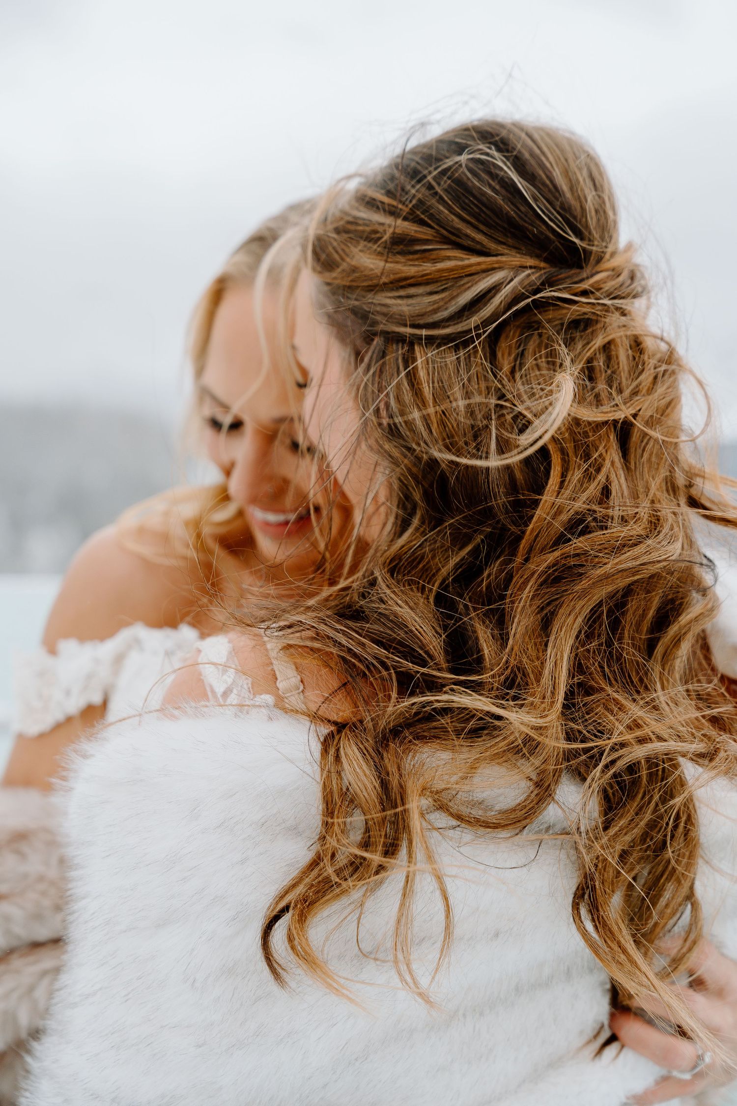 Close-up shot of wavy blonde hair blowing in the wind against a bright background.