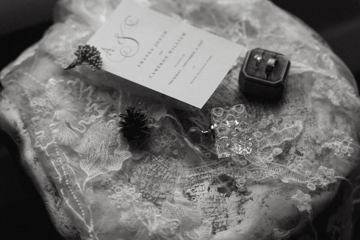 A collection of delicate white lace and fabric wedding accessories arranged on a vintage surface.