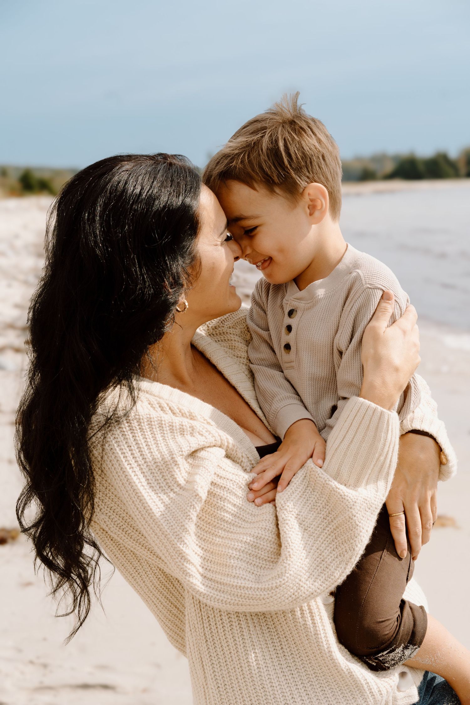 Tender moments shared between parent and child on a sunny beach.