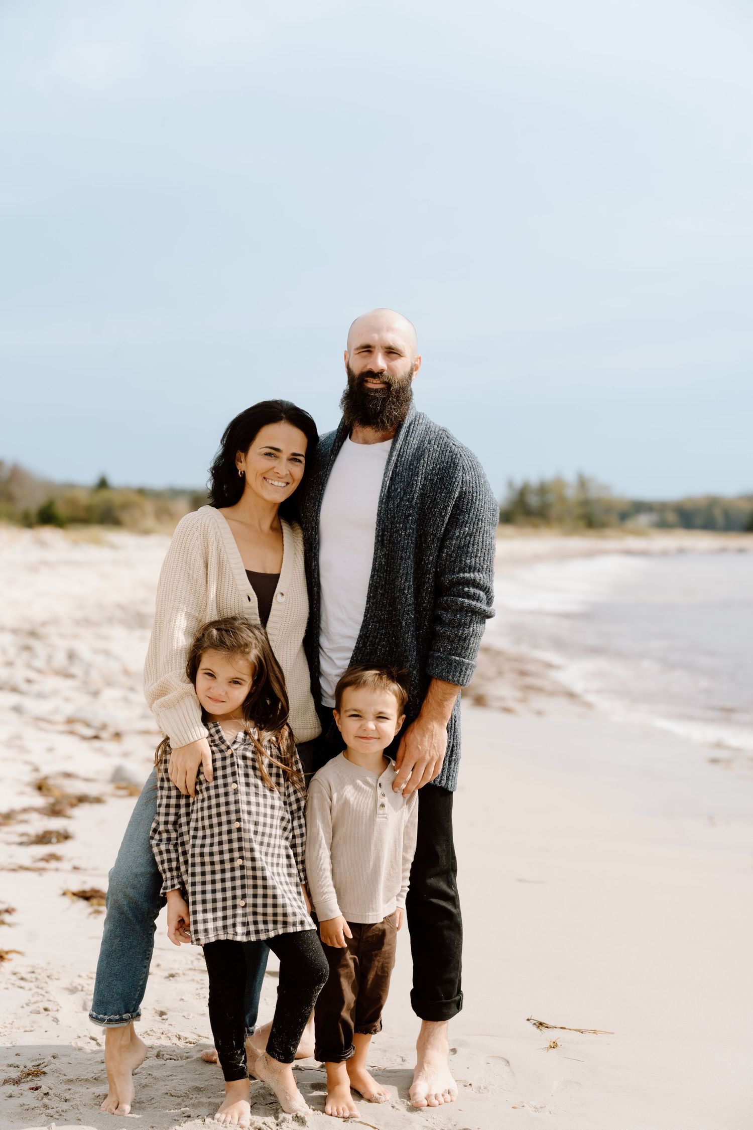 Family portrait session on a peaceful beach with soft lighting.