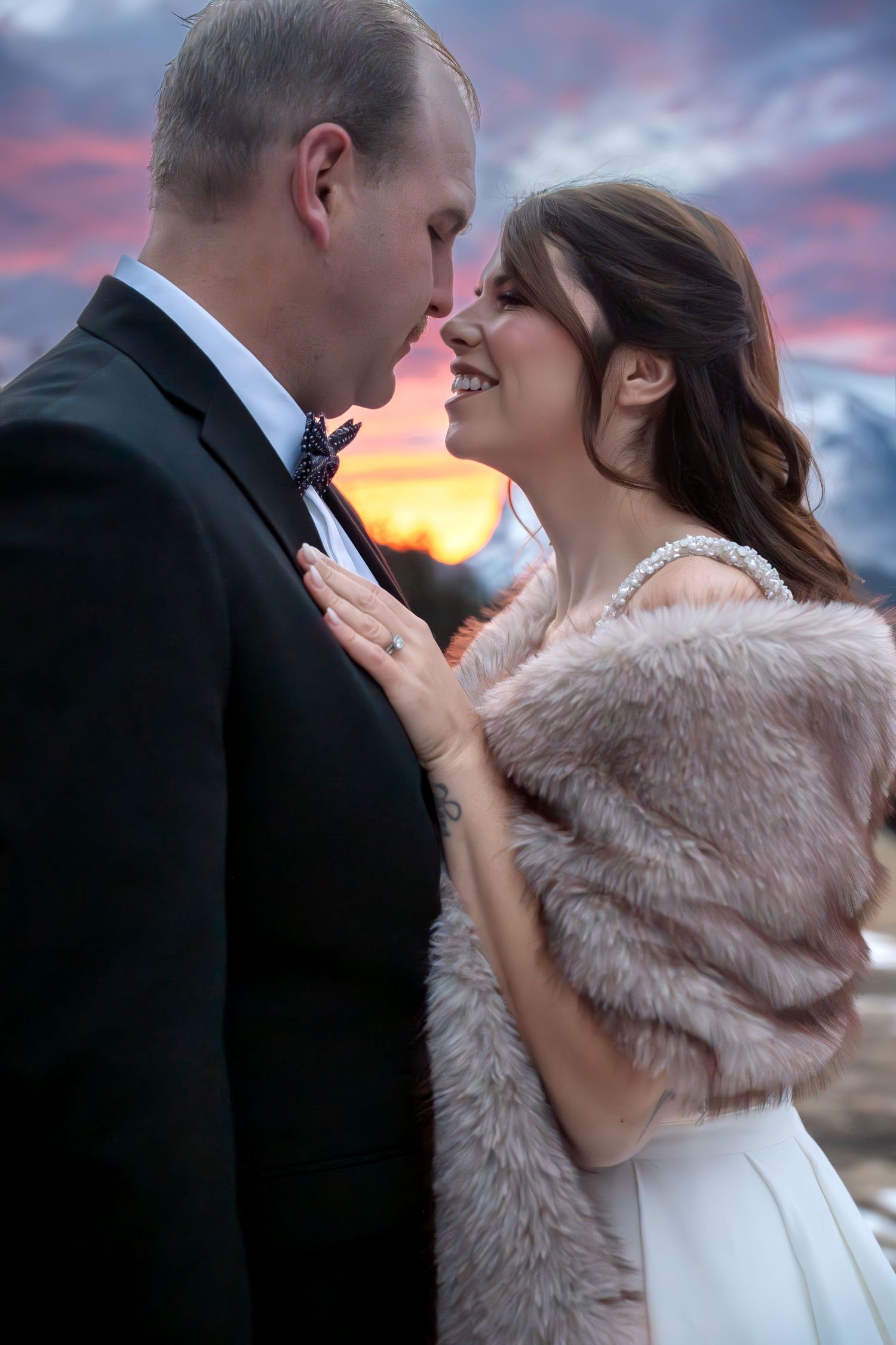 Romantic sunset wedding photos with couple in formal attire and fur wrap.