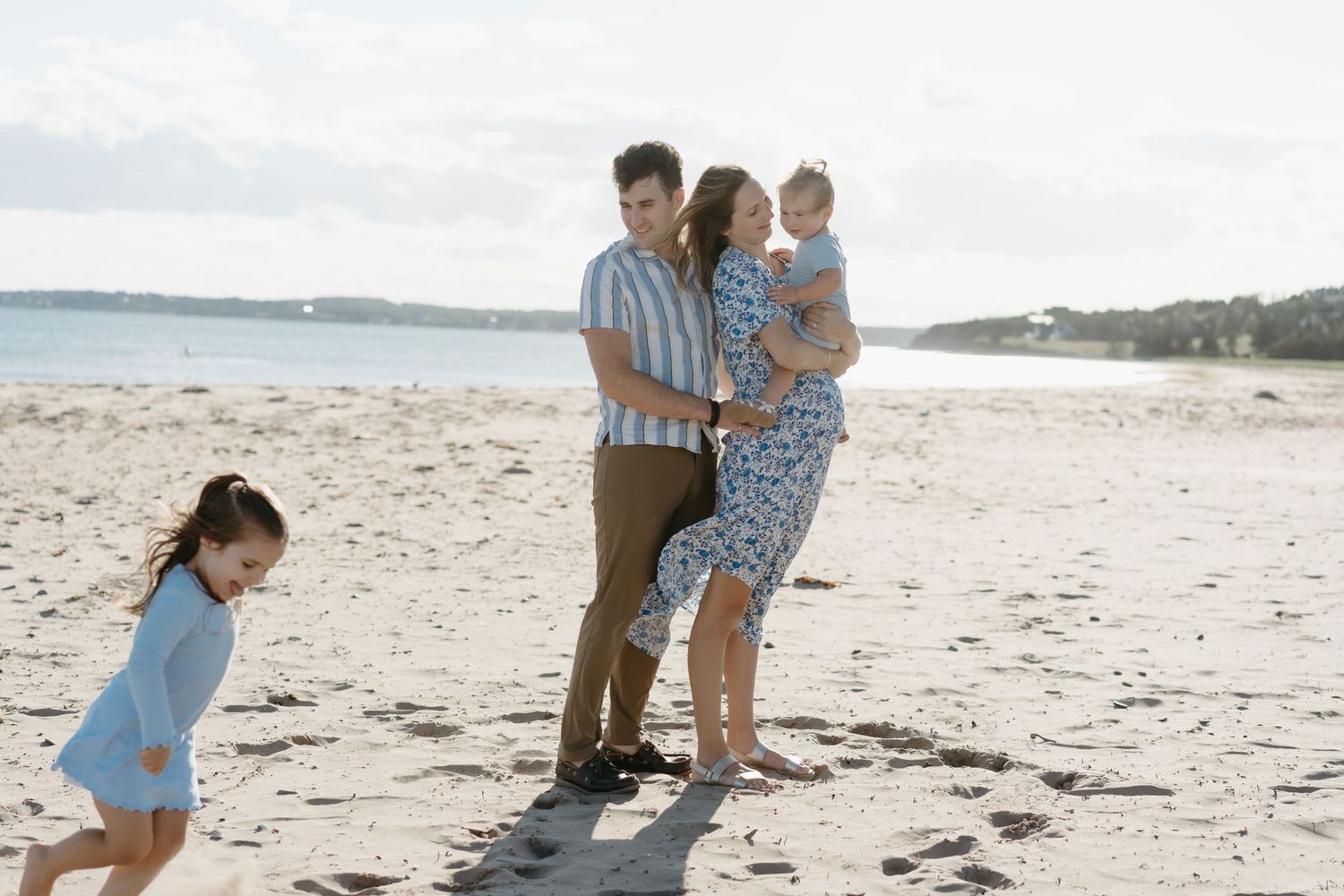 Family enjoying a sunny day together at a scenic beach.