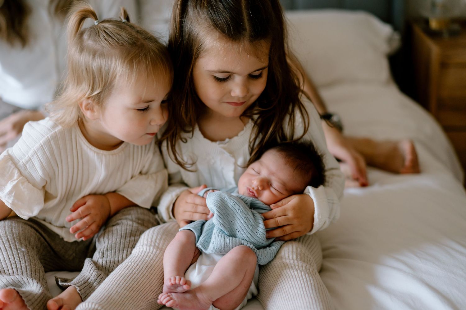 Loving family embraces and shares affectionate moments together on a bed.