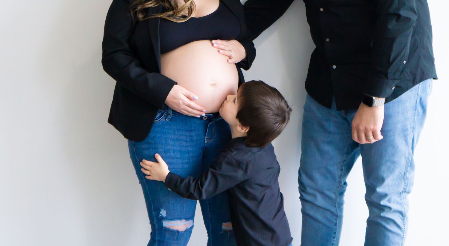 Casual lifestyle family portrait session against white wall background.