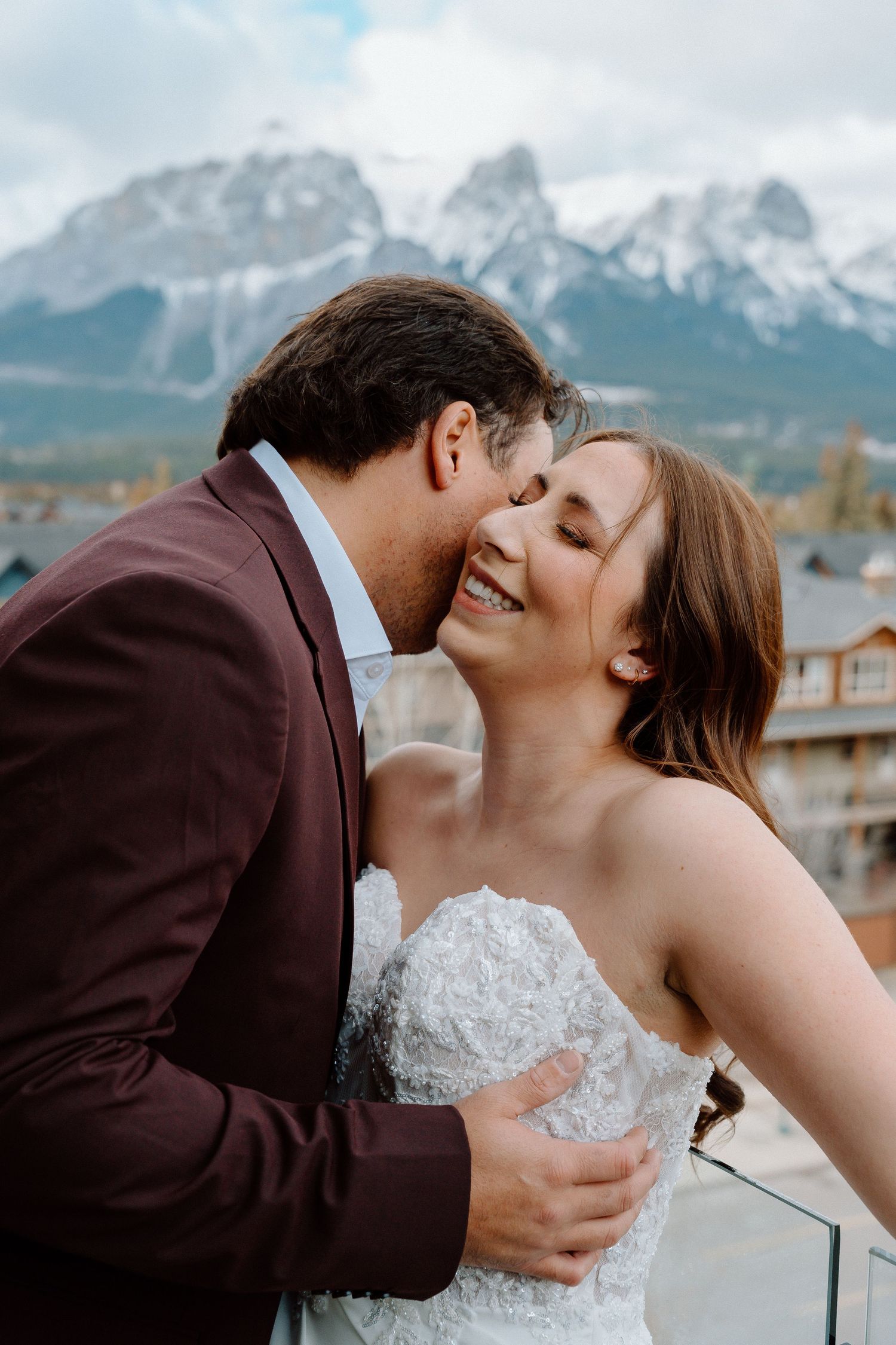 Romantic wedding moment captured against the majestic backdrop of mountain peaks.