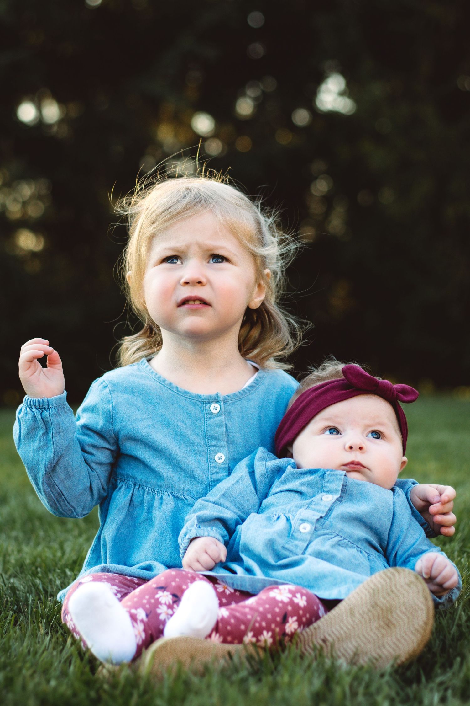 Toddler holding baby sister with grumpy face, Metro Detroit family photography, Sam Jackson Photography.