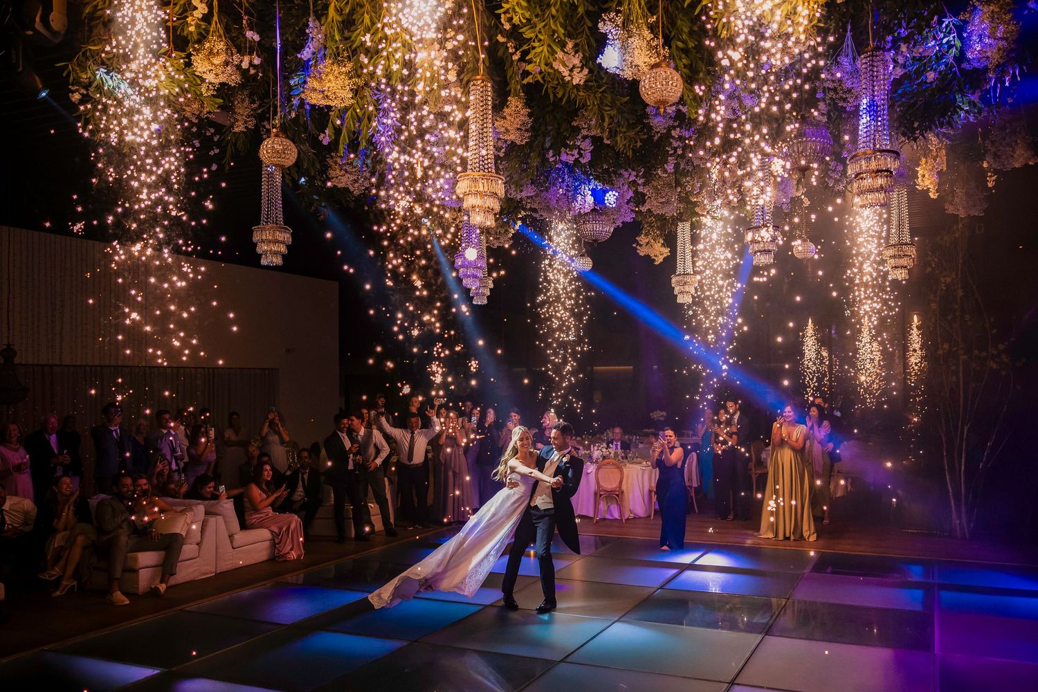 Wedding dance under sparkling lights and illuminated decor in elegant venue in Porto, Portugal.