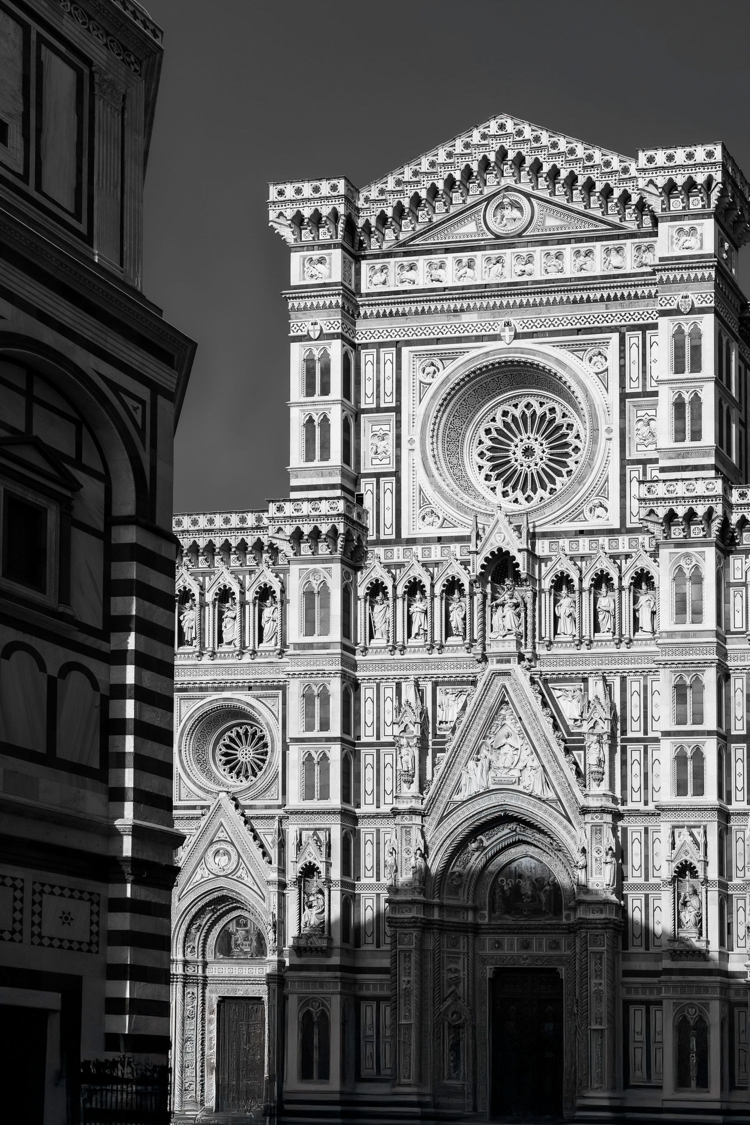 The elaborate Gothic facade of Florence's Duomo cathedral in striking monochrome detail.