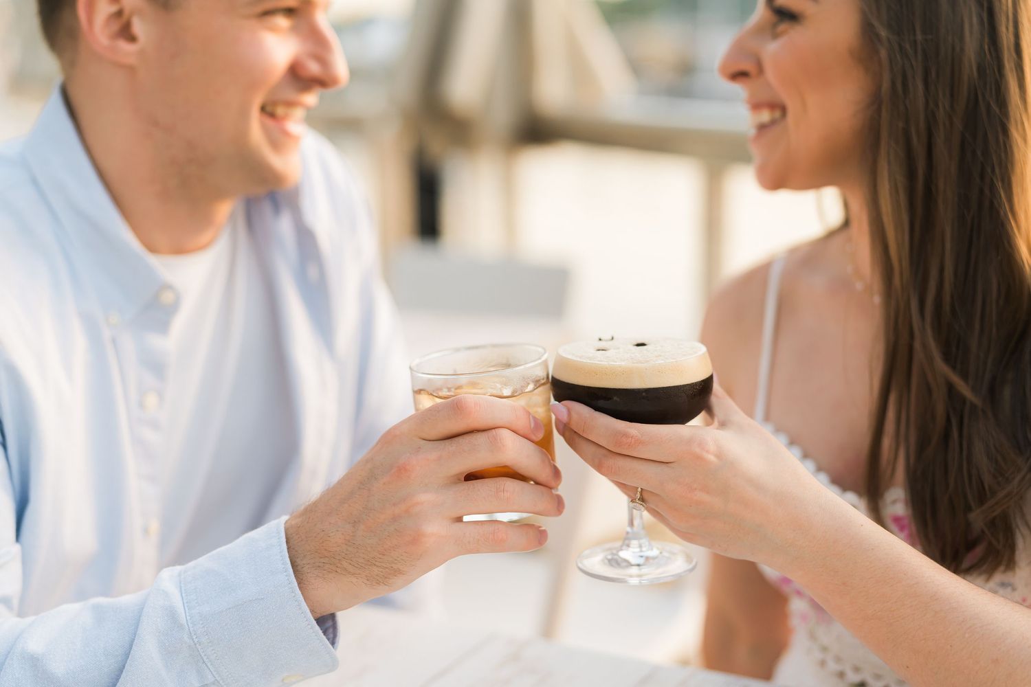 Couple toasting with specialty coffee drinks during a romantic cafe date.
