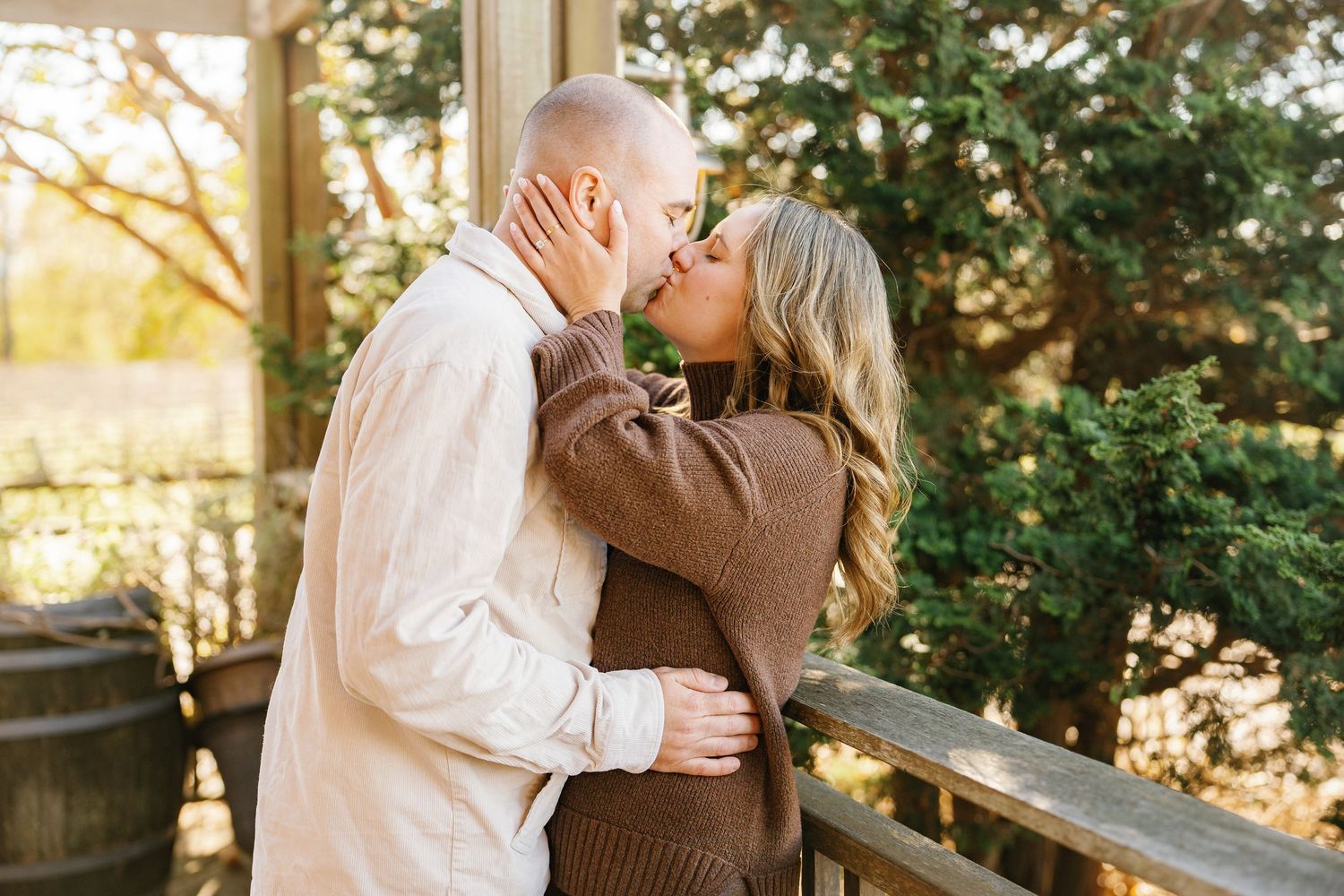 A romantic couple shares tender moments in a sunlit garden setting during a wedding photo session.