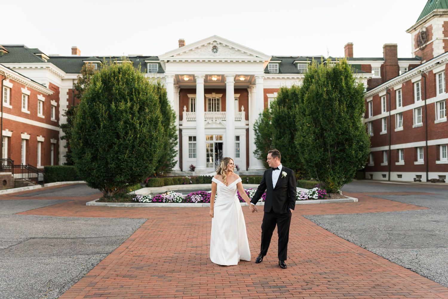 Elegant wedding portrait in front of historic colonial-style building with white columns.