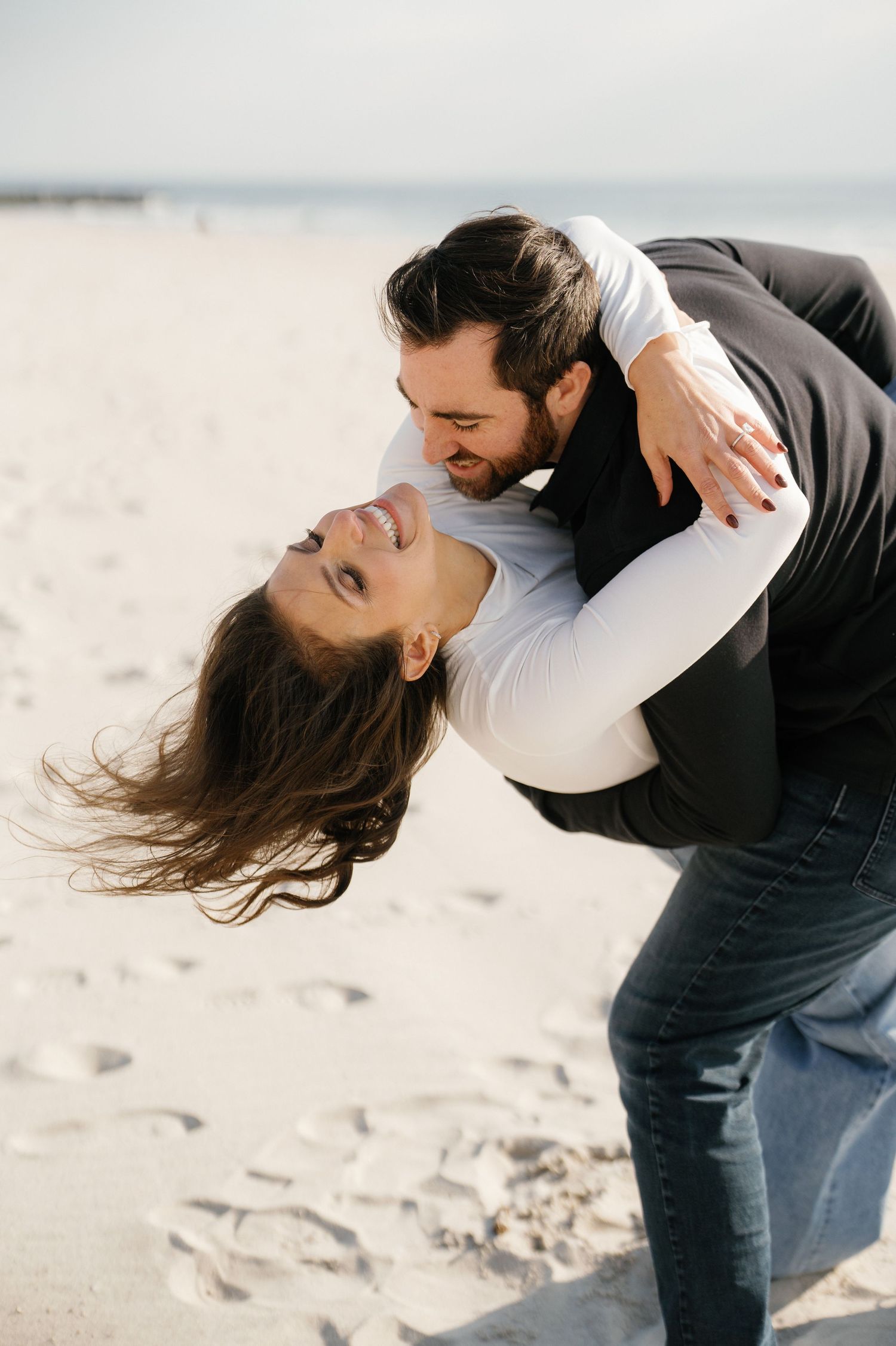 A couple dances intimately on a sandy beach, creating a romantic sequence of dance dip poses at sunset.