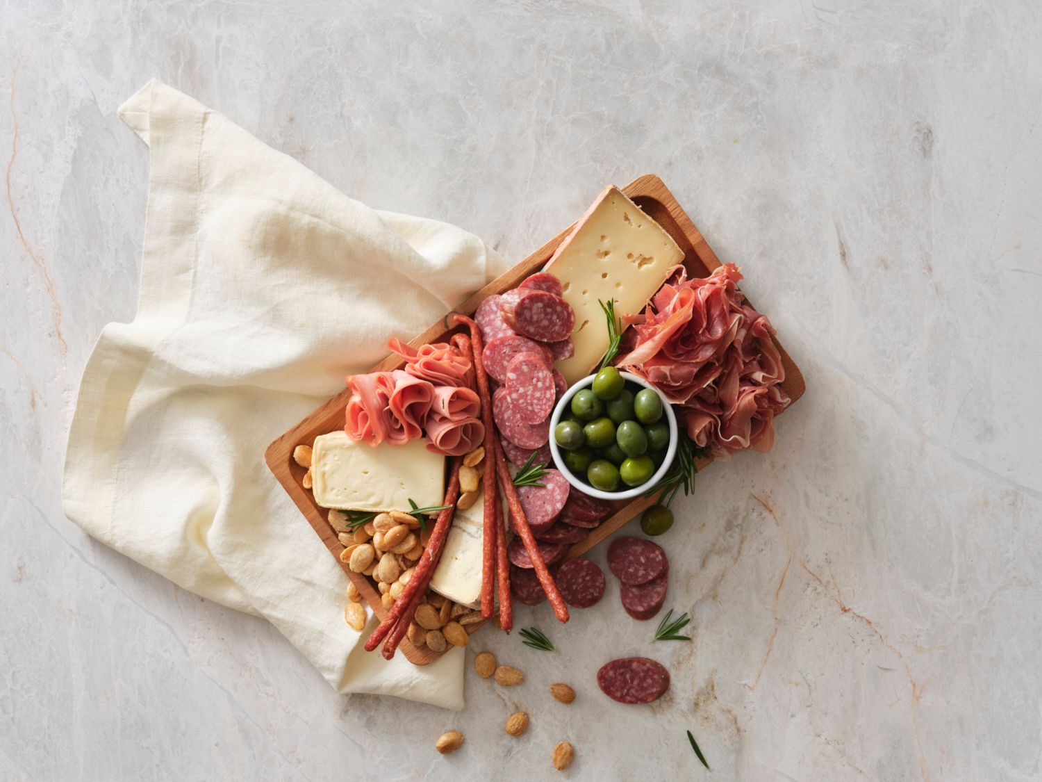 Overhead photo of a charcuterie board and a cream linen napkin