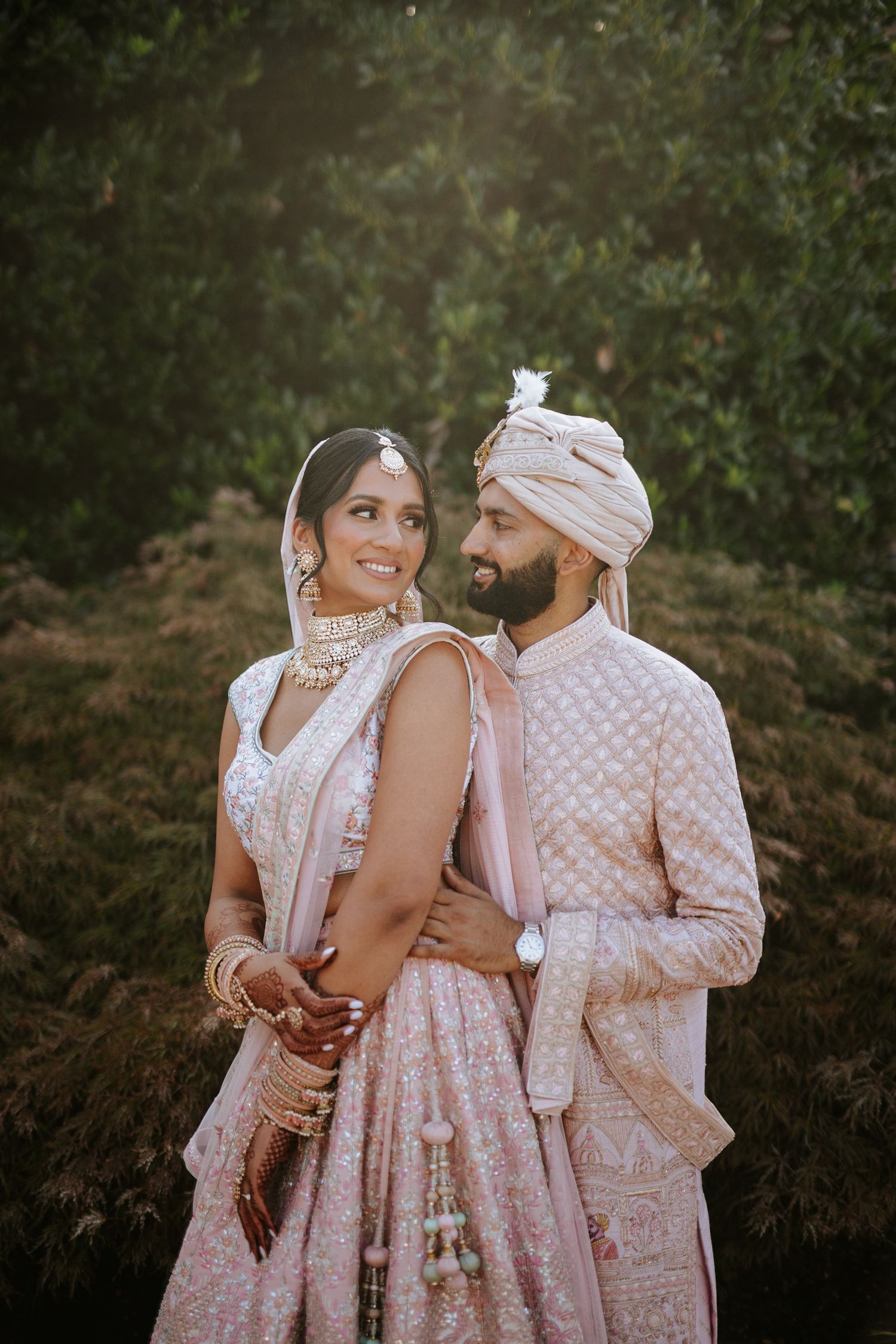 Romantic South Asian wedding portrait at The Rockleigh in New Jersey, featuring the couple in pastel attire against a lush outdoor backdrop.