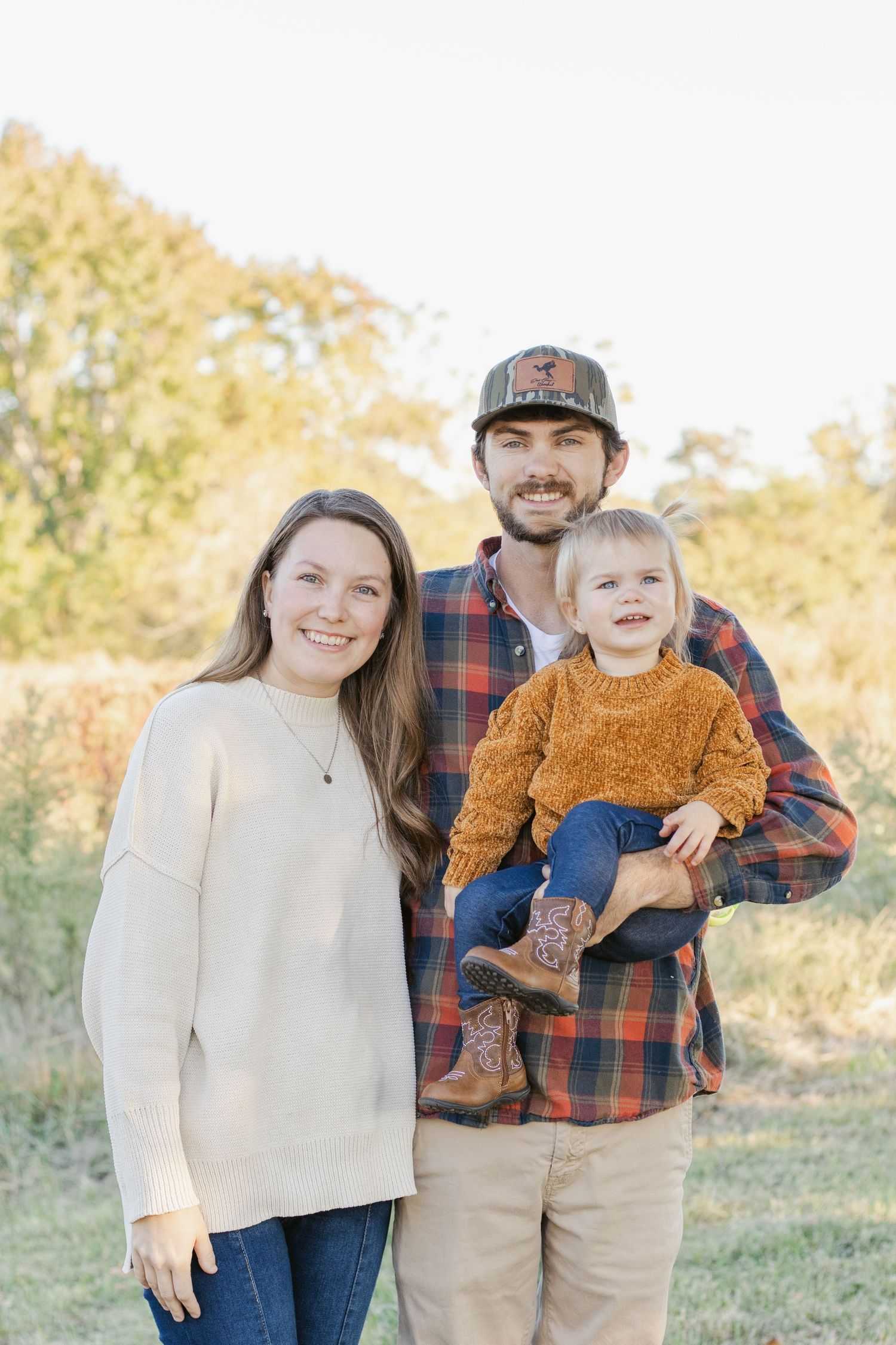 Family enjoying a sunny autumn day together outdoors in casual sweaters.