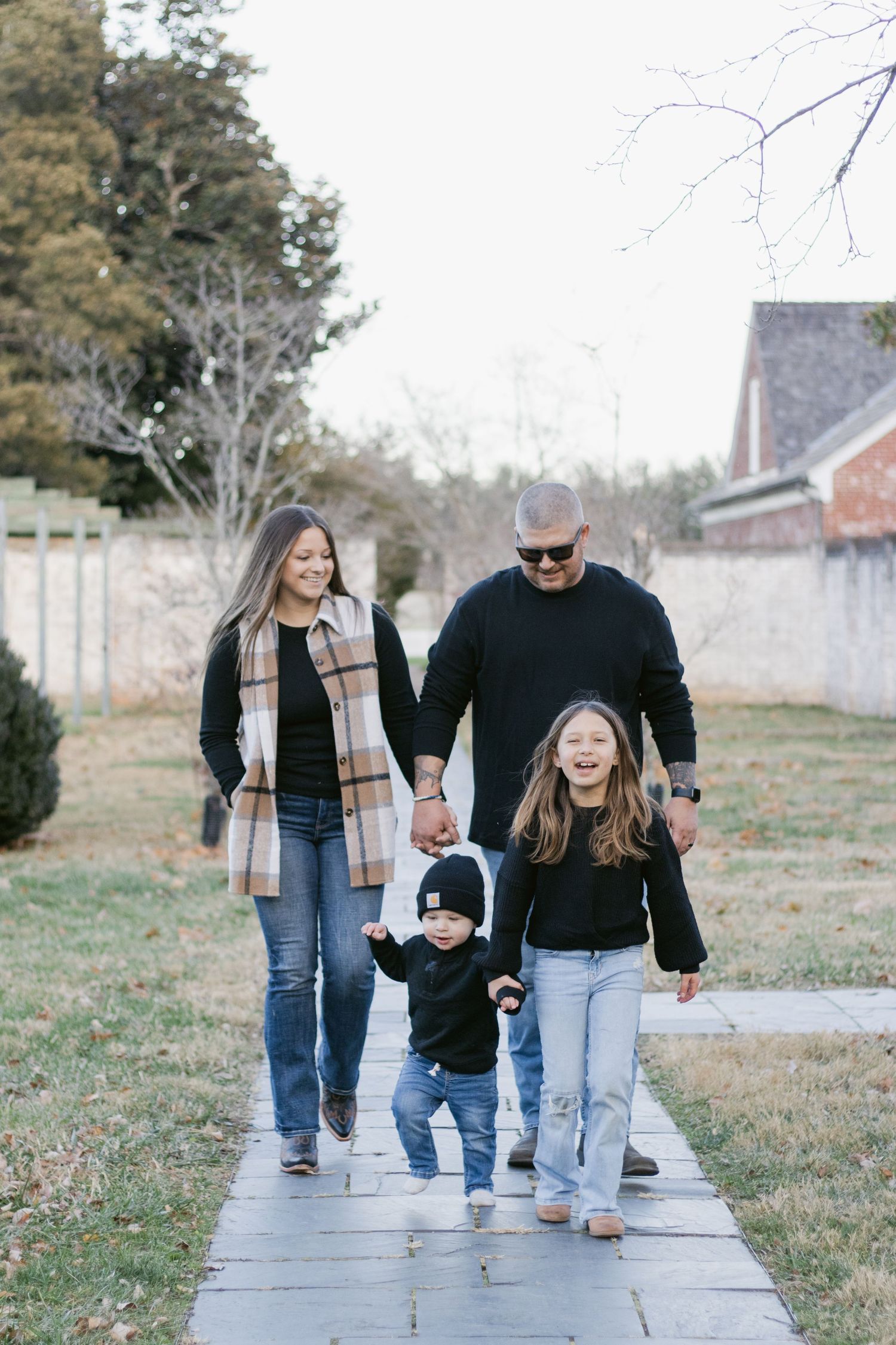 Three people walking together on a concrete path enjoying a casual outdoor stroll.