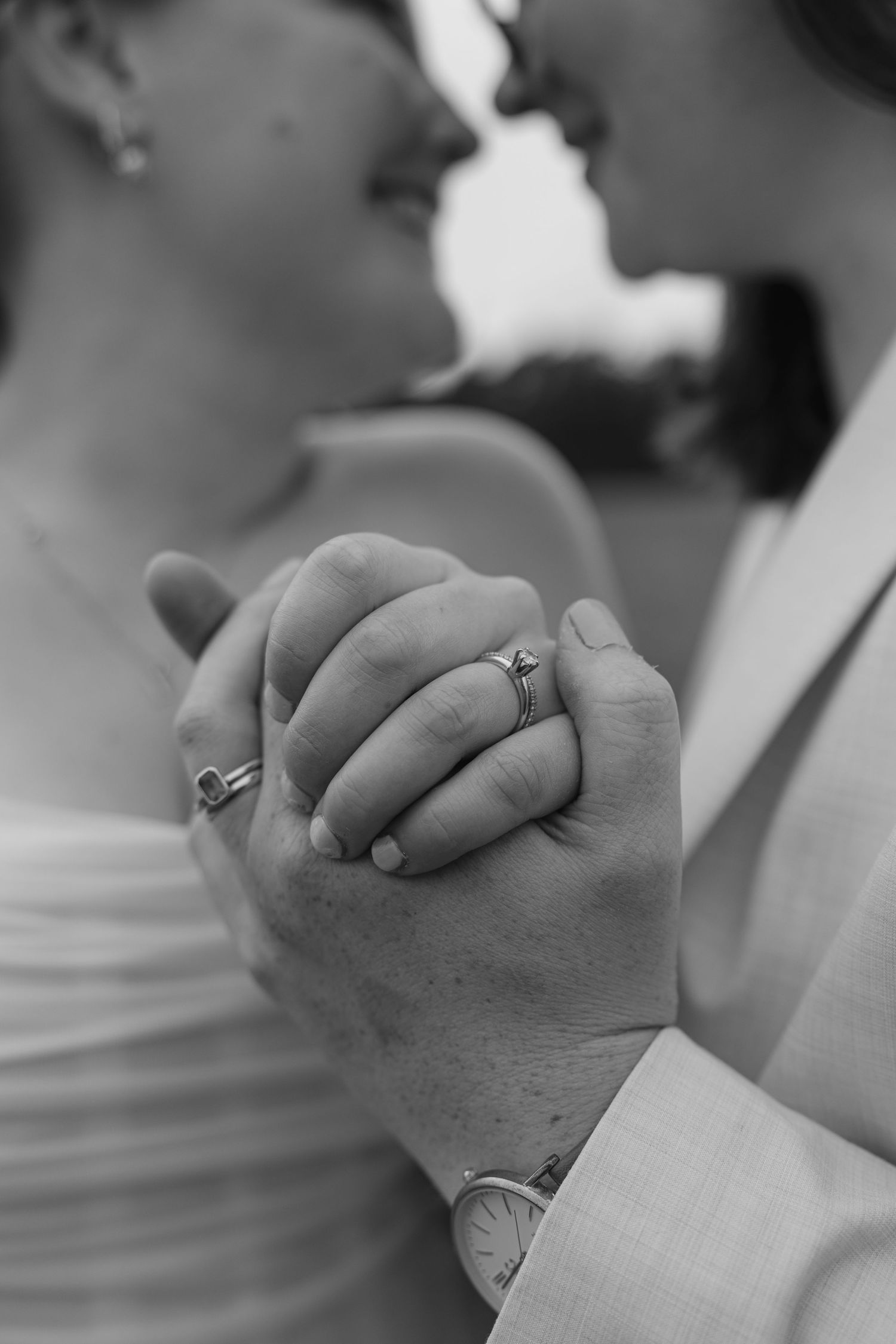 A series of black and white photos showing two hands clasped together wearing wedding rings in different angles.