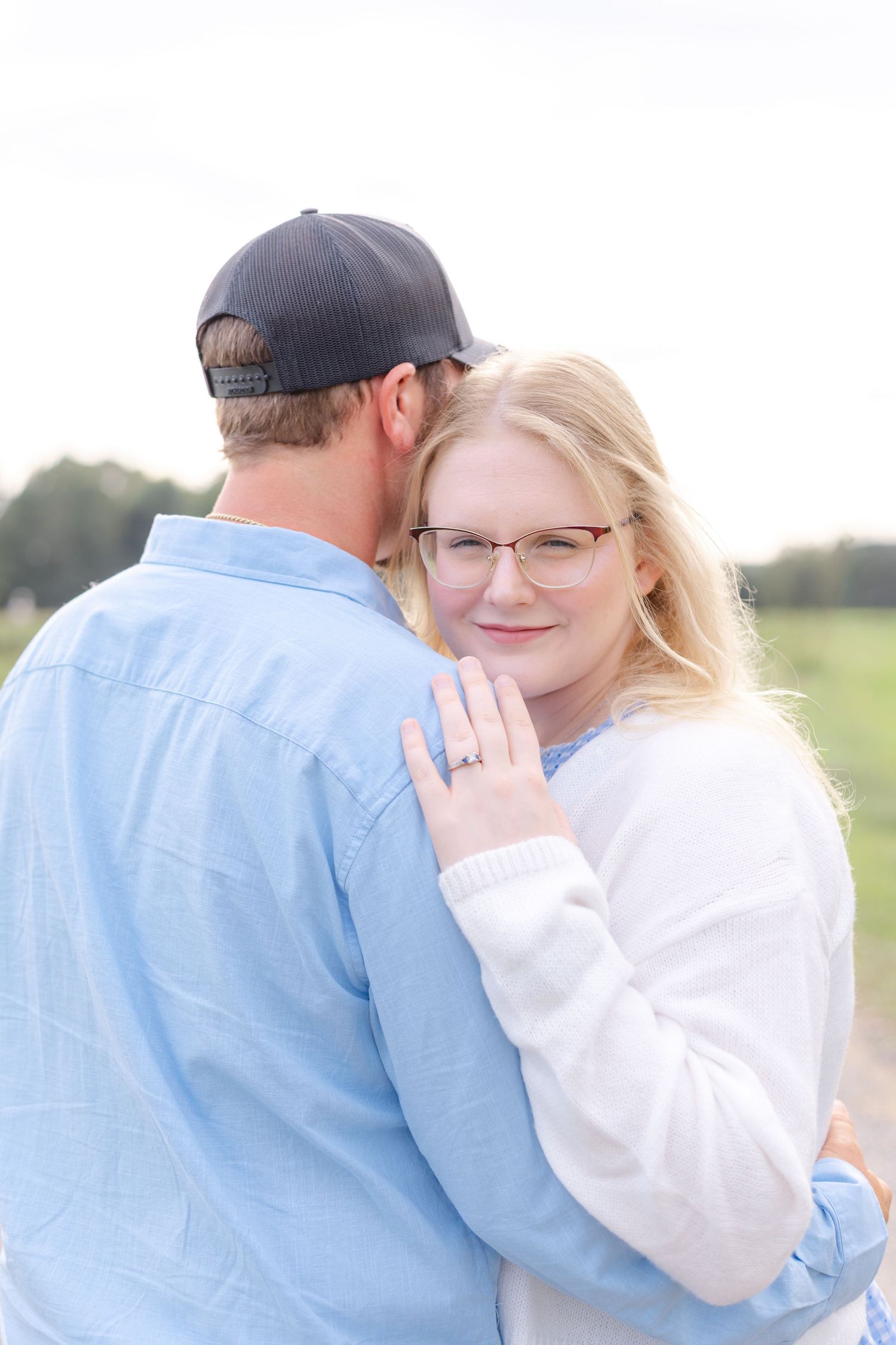 A romantic outdoor photo sequence showing a couple embracing in soft natural light against a rural backdrop.