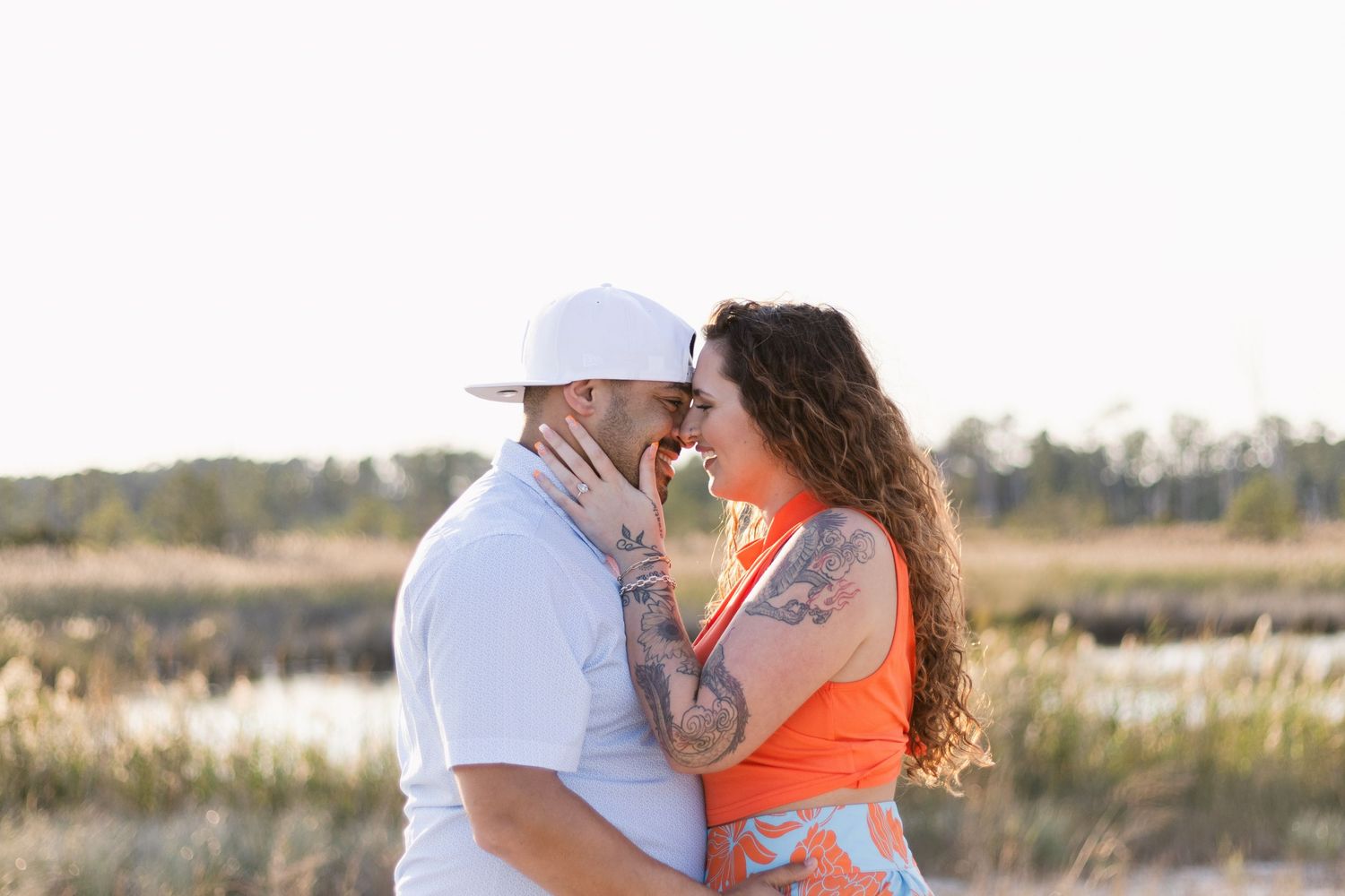 A couple in light and orange attire shares tender moments in series of photos taken on a sandy beach.