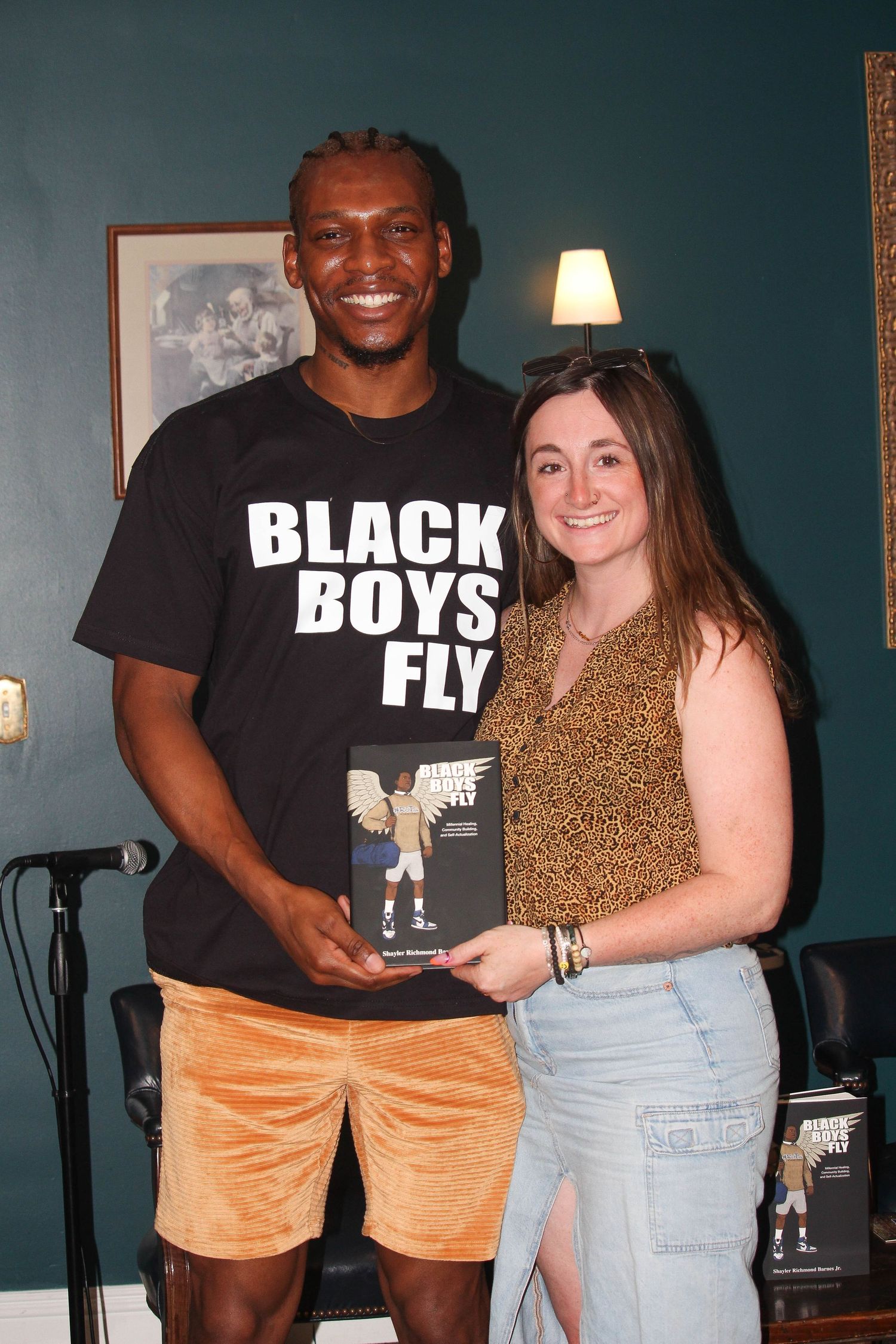 Man in Black Boys Fly shirt poses with woman holding the Black Boys Fly book.