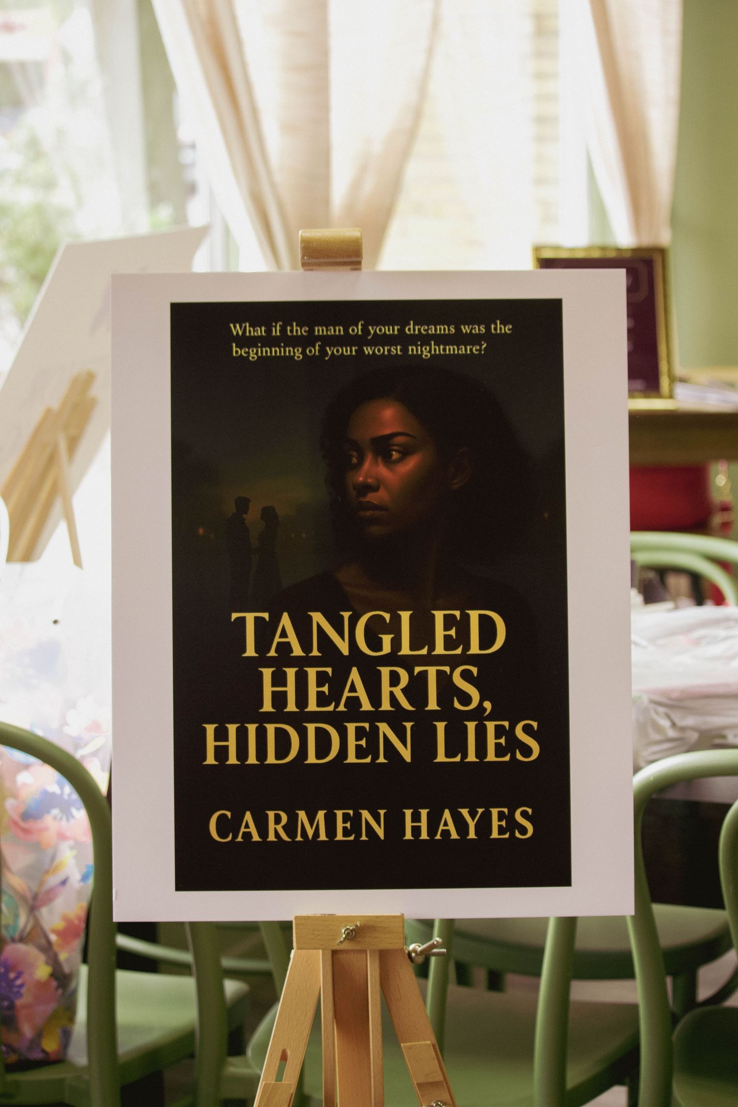 Book cover display for Tangled Hearts Hidden Lies by Carmen Hayes on an easel at a book signing event.