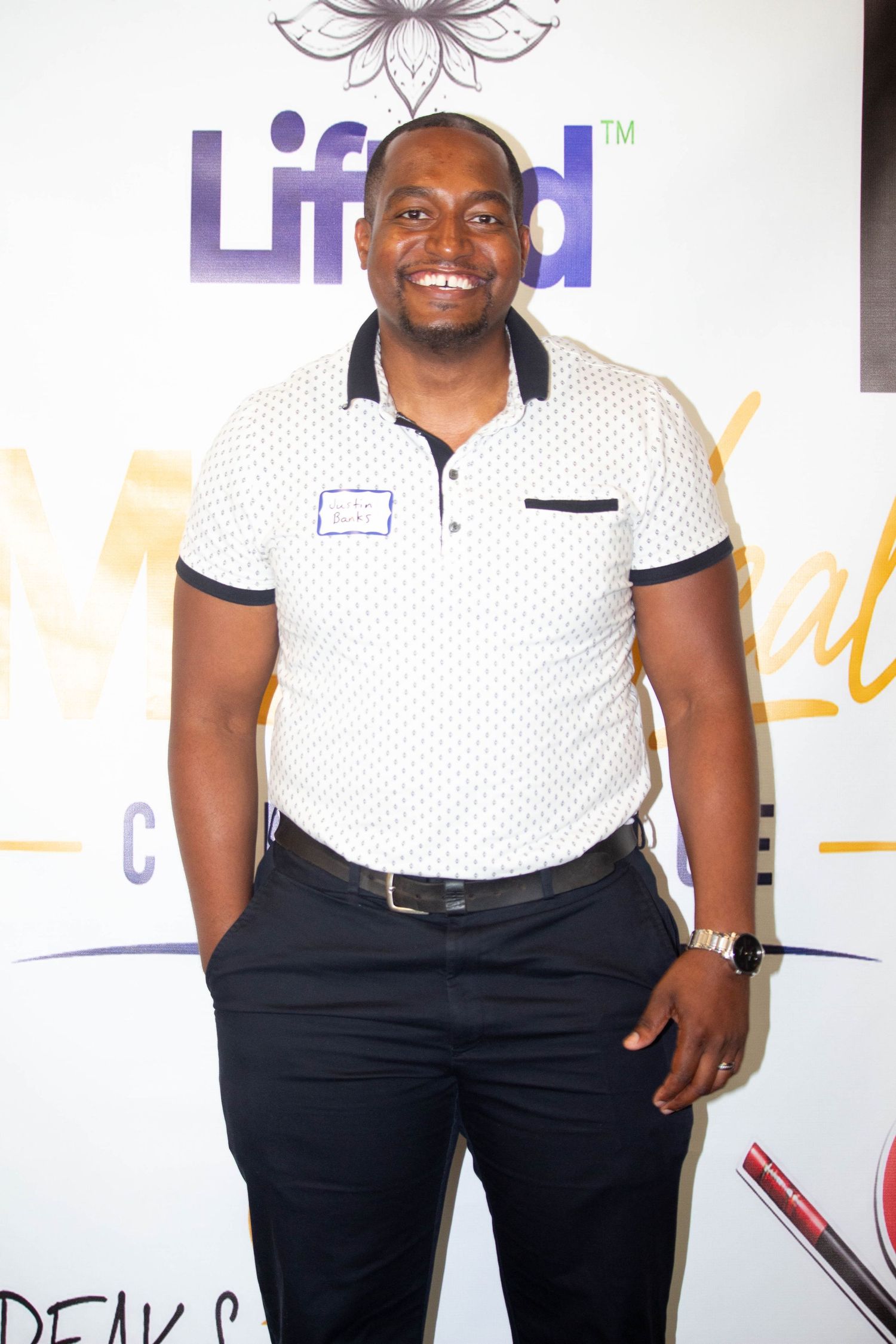 Smiling man in a white polo shirt posing at a Lifeed event backdrop.