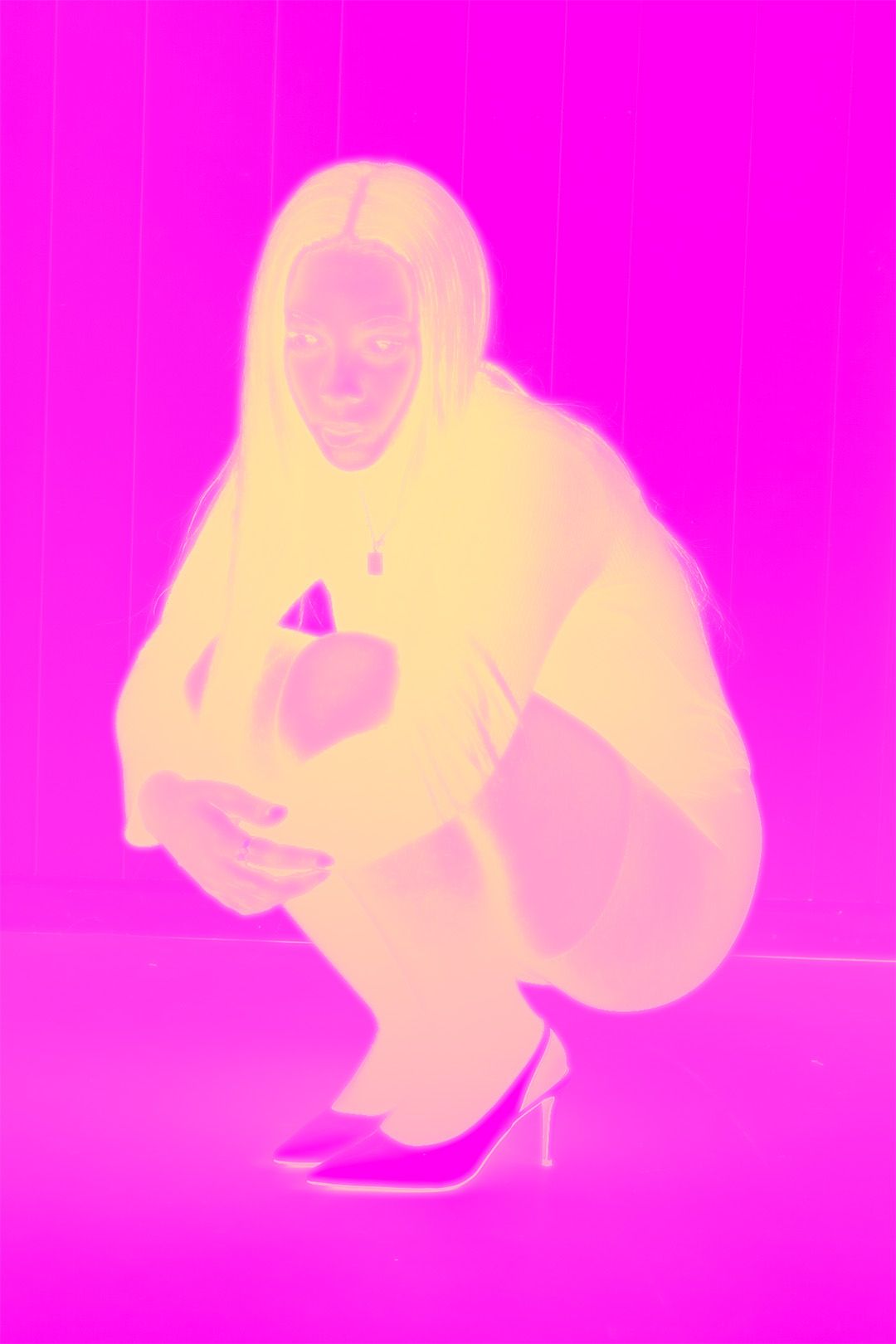 A person crouching in high heels, rendered in vivid yellow and magenta duotone artistic photography.