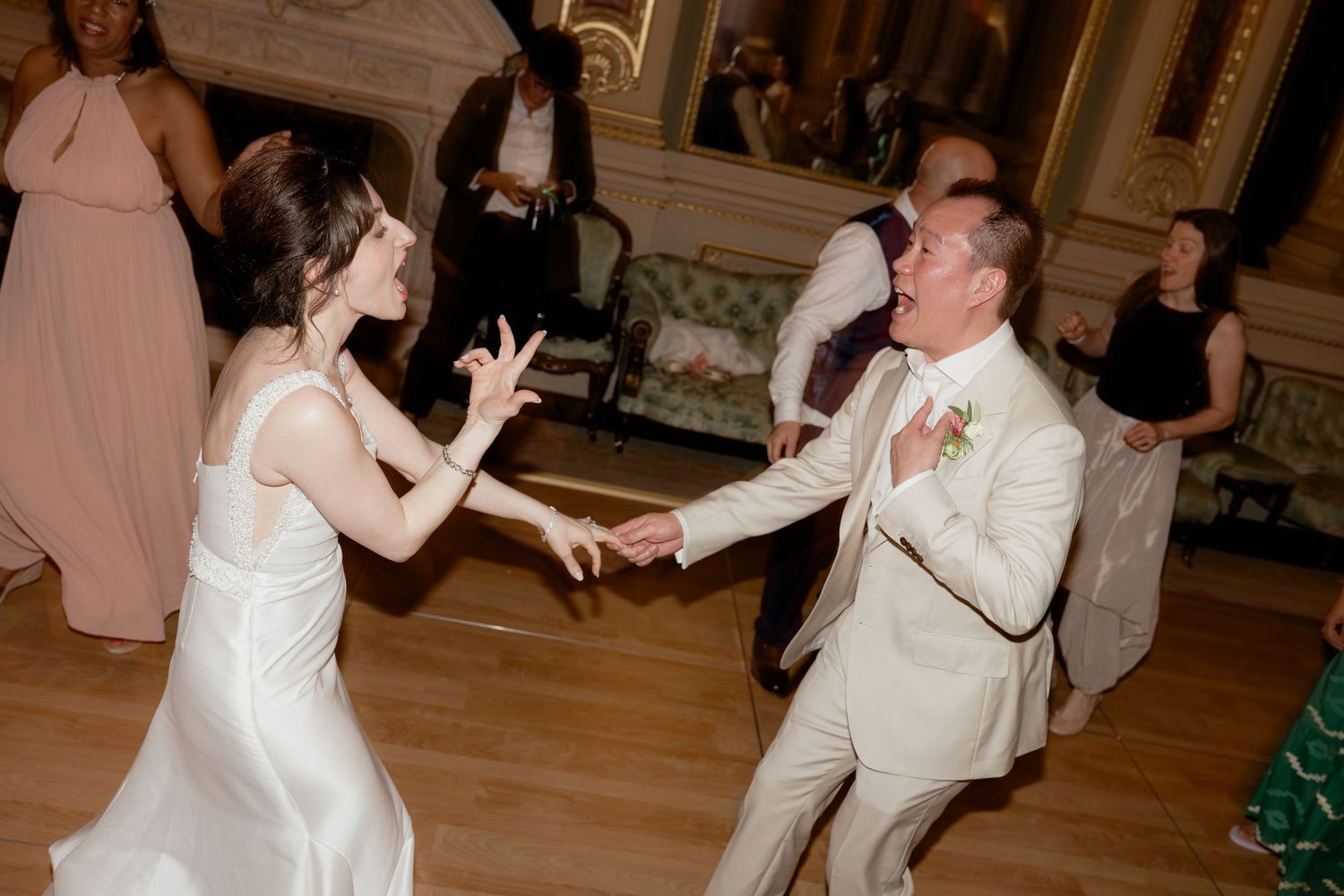 Bride and groom dance energetically together on the dance floor at their wedding reception.