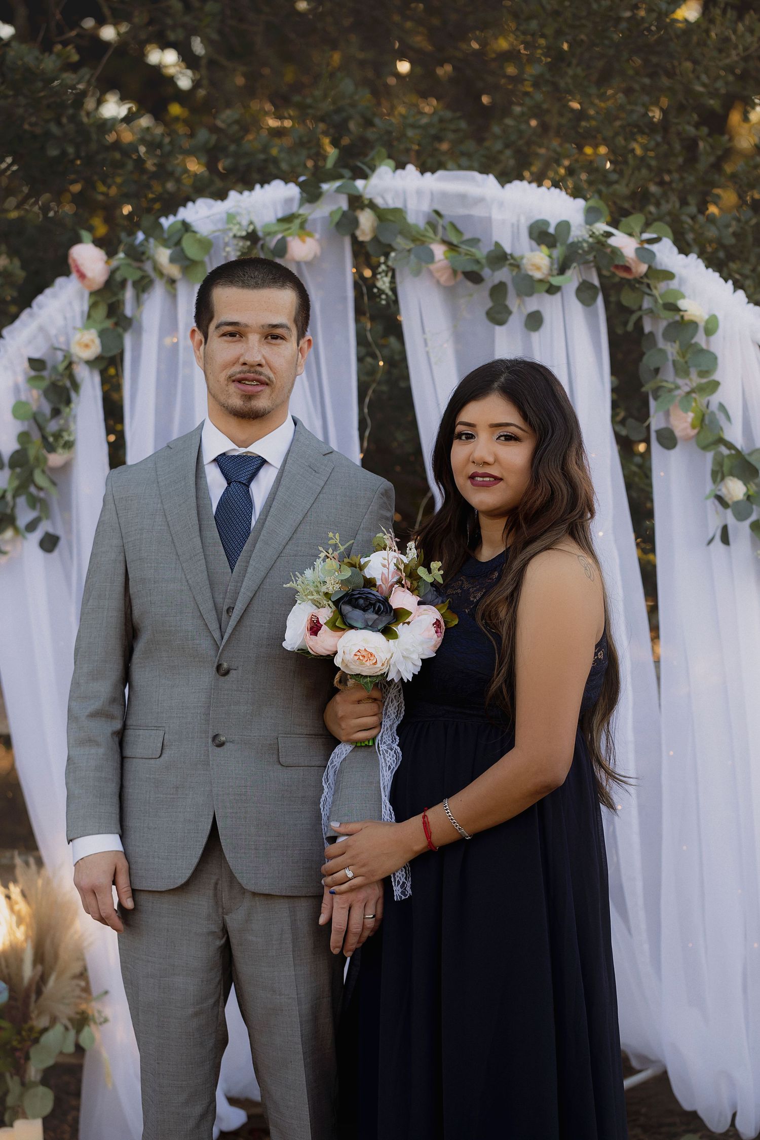 intimate elopement portrait of a couple standing beneath a floral ceremony arch in Santa Rosa, california