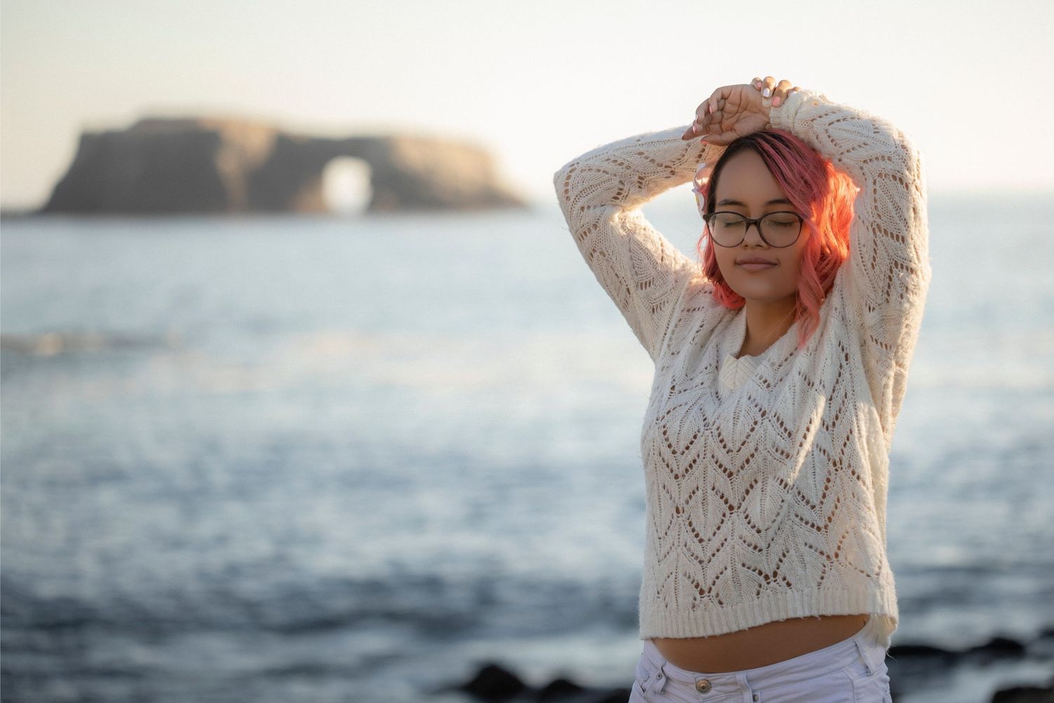 Senior portrait of a young woman photographed on the coast with ocean views in the background