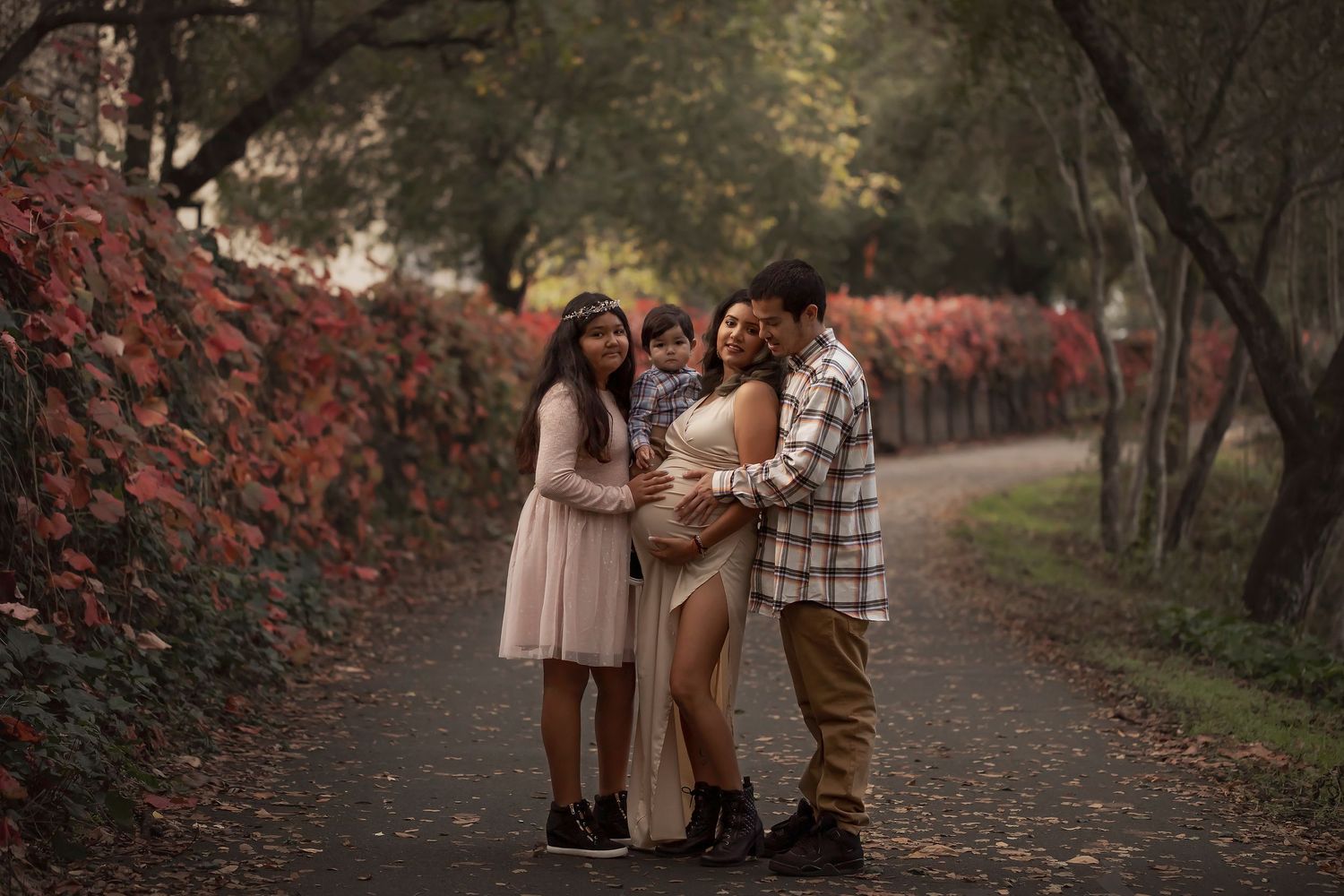 Family portrait session on a tree-lined path during autumn in Sonoma County.