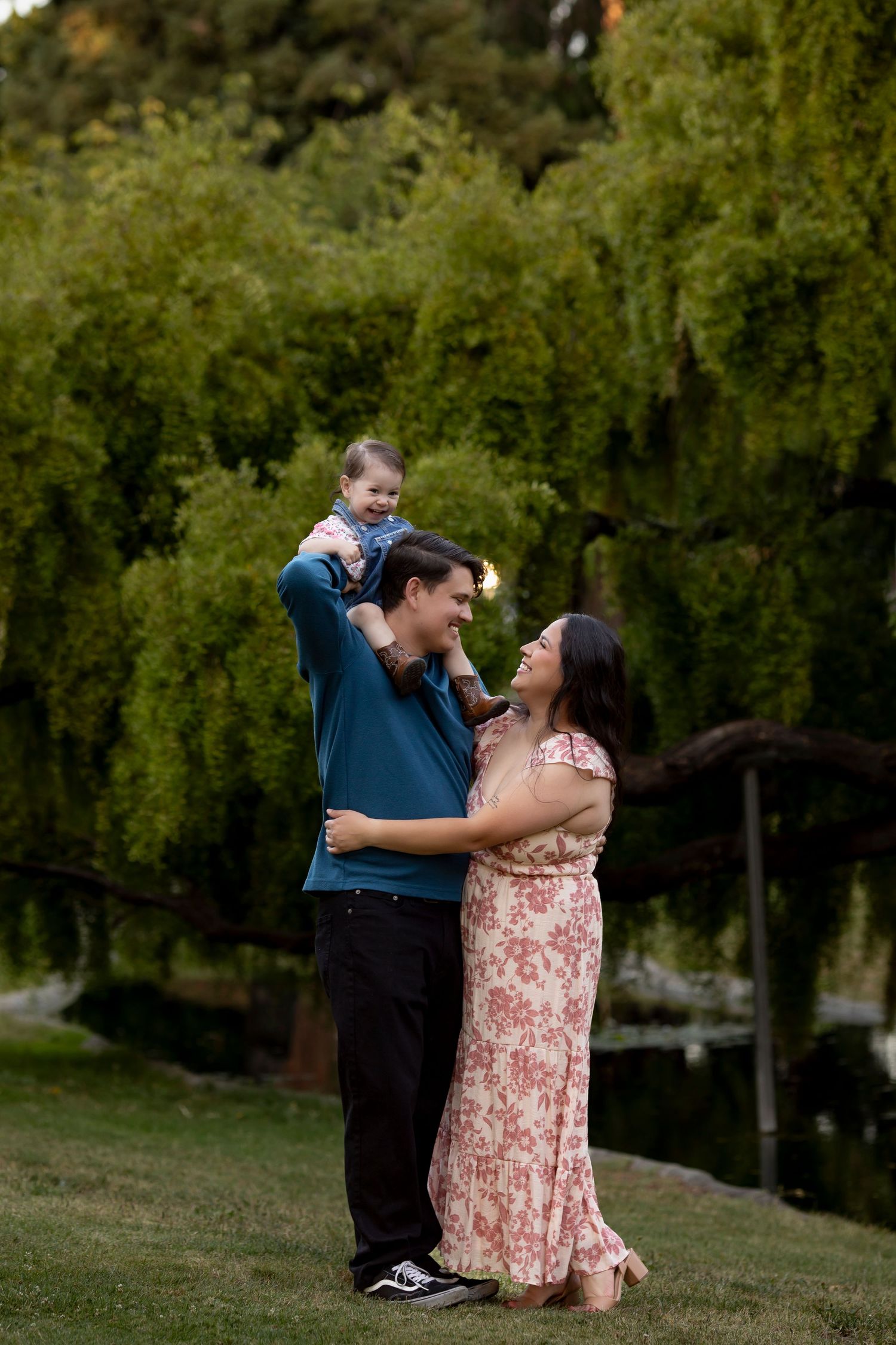 Mother, father and infant daughter sharing a playful outdoor moment during a fine art family portrait session in Santa Rosa, California