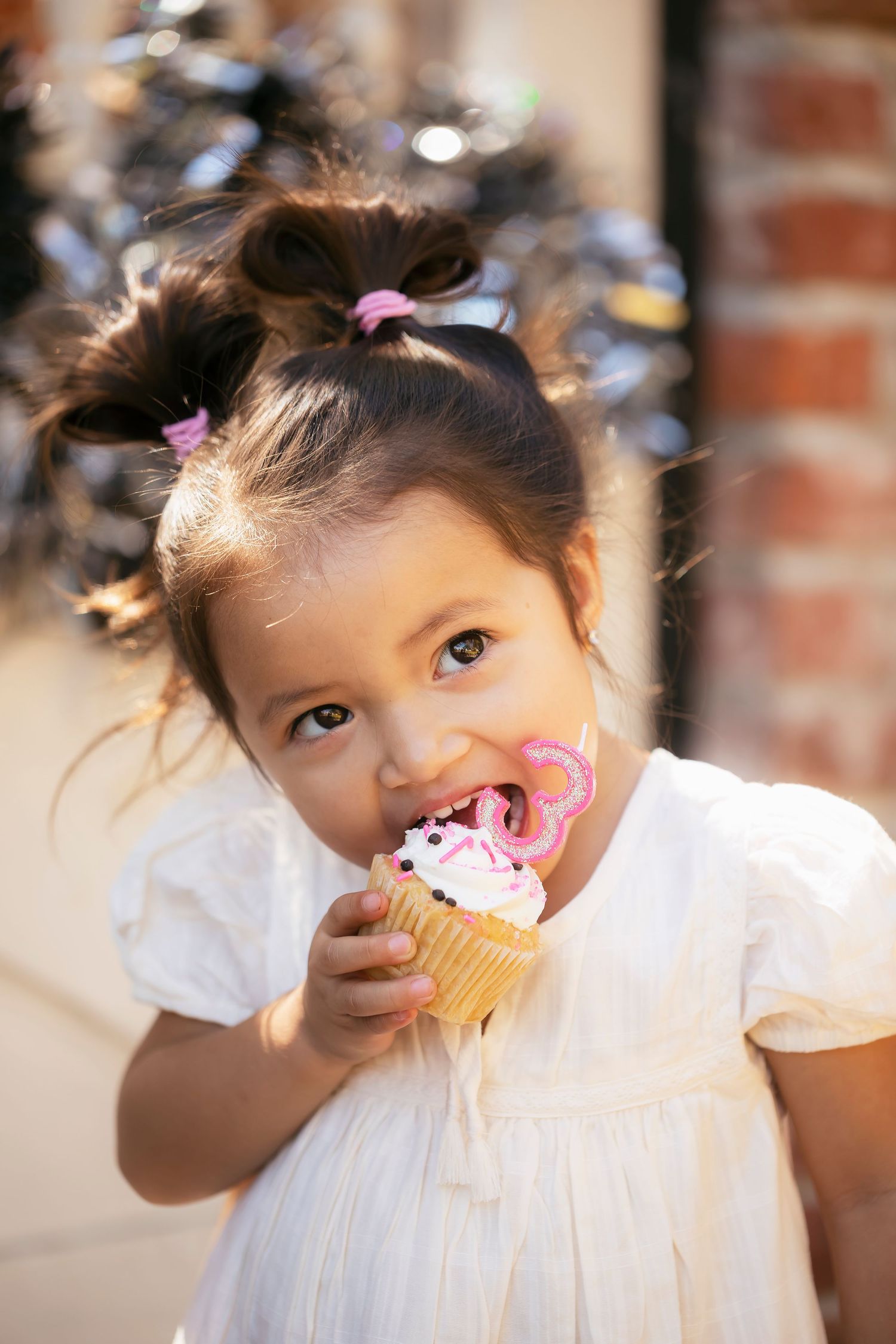 Child portrait of a toddler enjoying a birthday cupcake in soft natural light