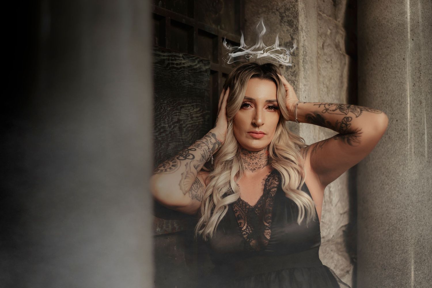 Fine art portrait of a woman wearing an ornate crown and black gown, photographed in a moody, ethereal aesthetic