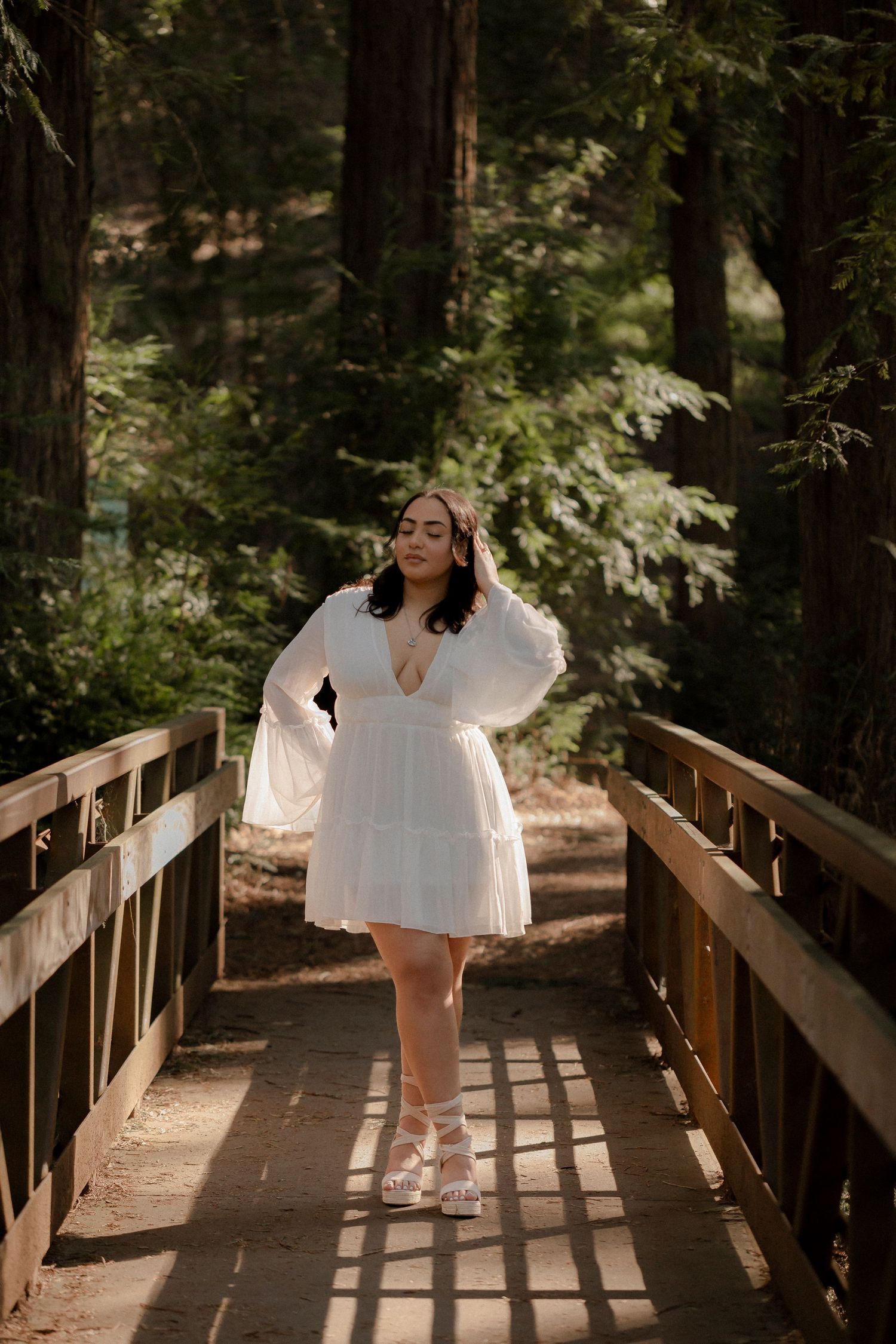 Outdoor senior portrait photographed on a forest bridge, surrounded by towering redwood trees
