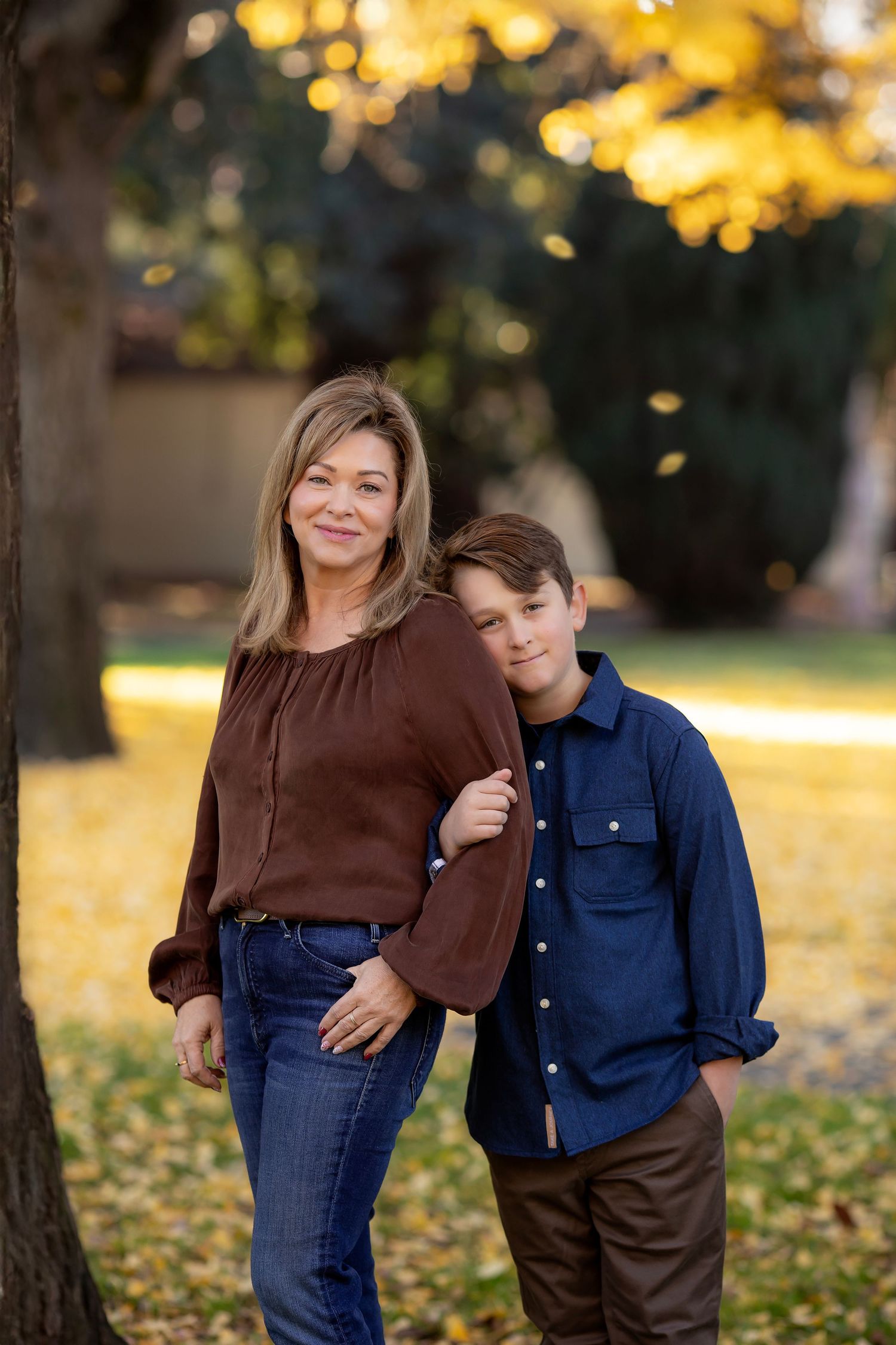 Family portrait featuring a mother and son photographed together in warm autumn light