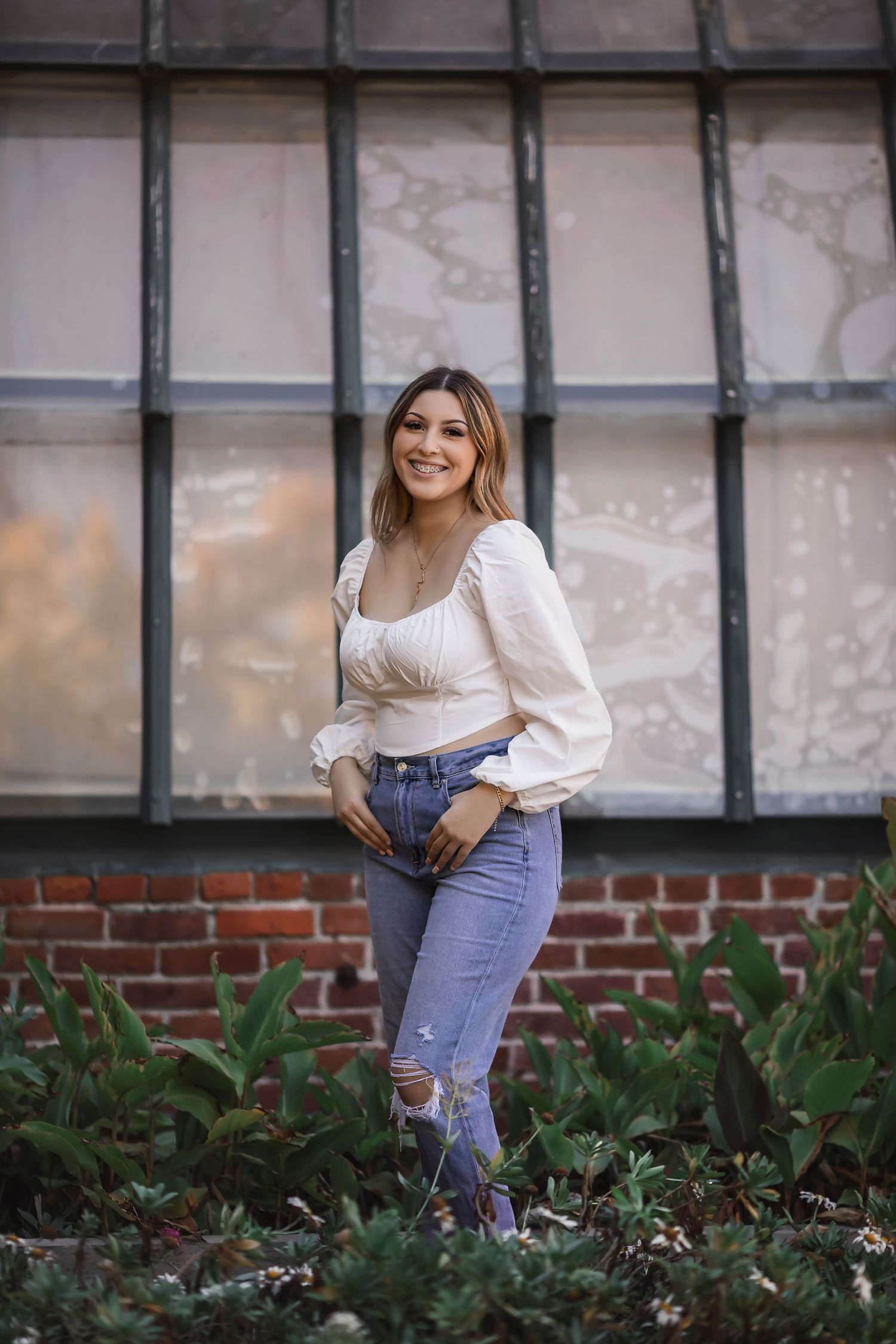High school senior portrait of a young woman standing outside a historic brick building in Santa Rosa, California