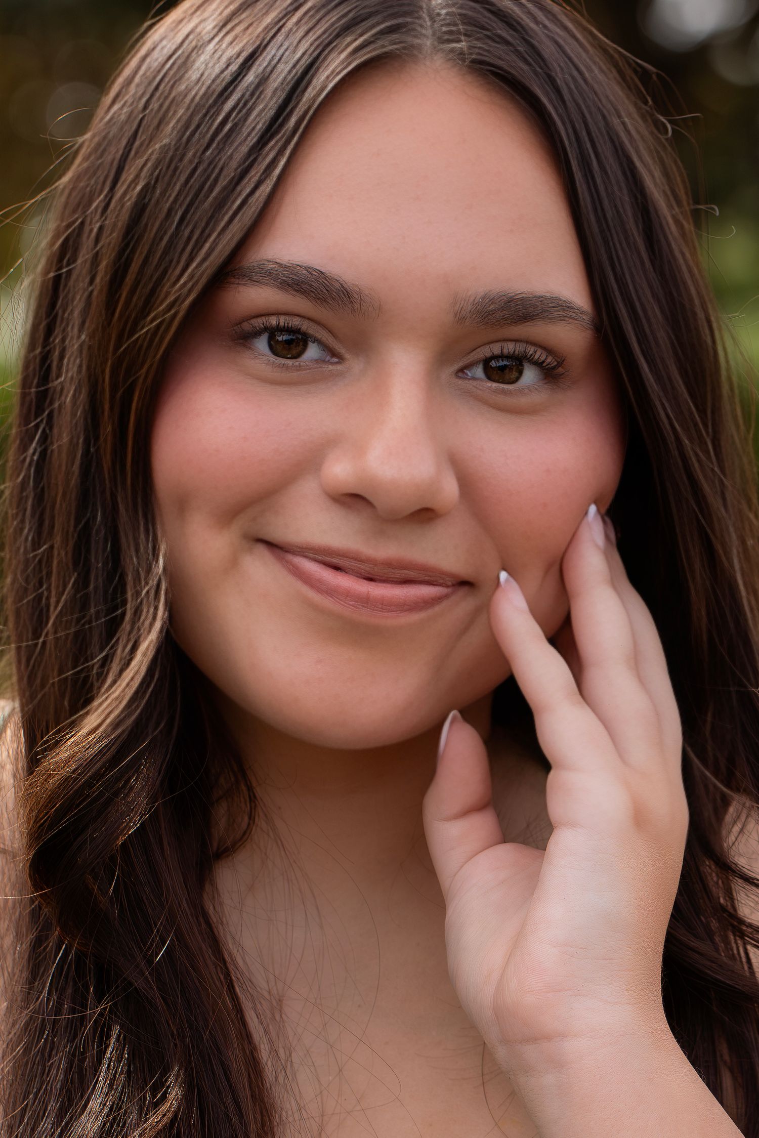 Natural light prom portrait of a young woman, smiling toward the camera during an outdoor photography session in Santa Rosa, California