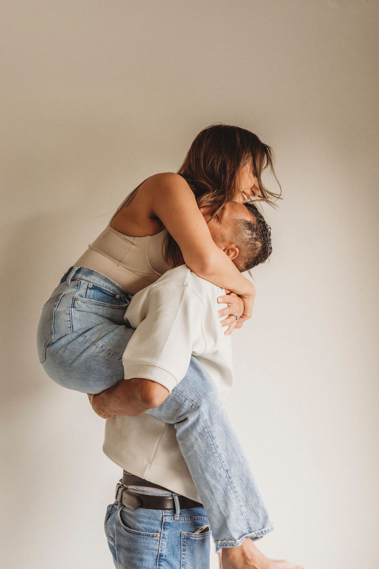 Playful couple portrait of a husband lifting his wife capturing authentic connection, movement and love.