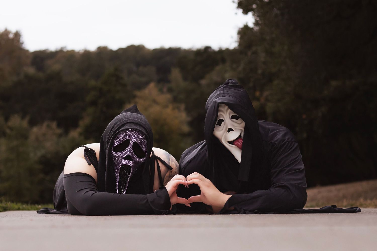 Create a couples portrait, featuring two people in Ghostface masks forming a heart shape during an artistic photography session in Sonoma co