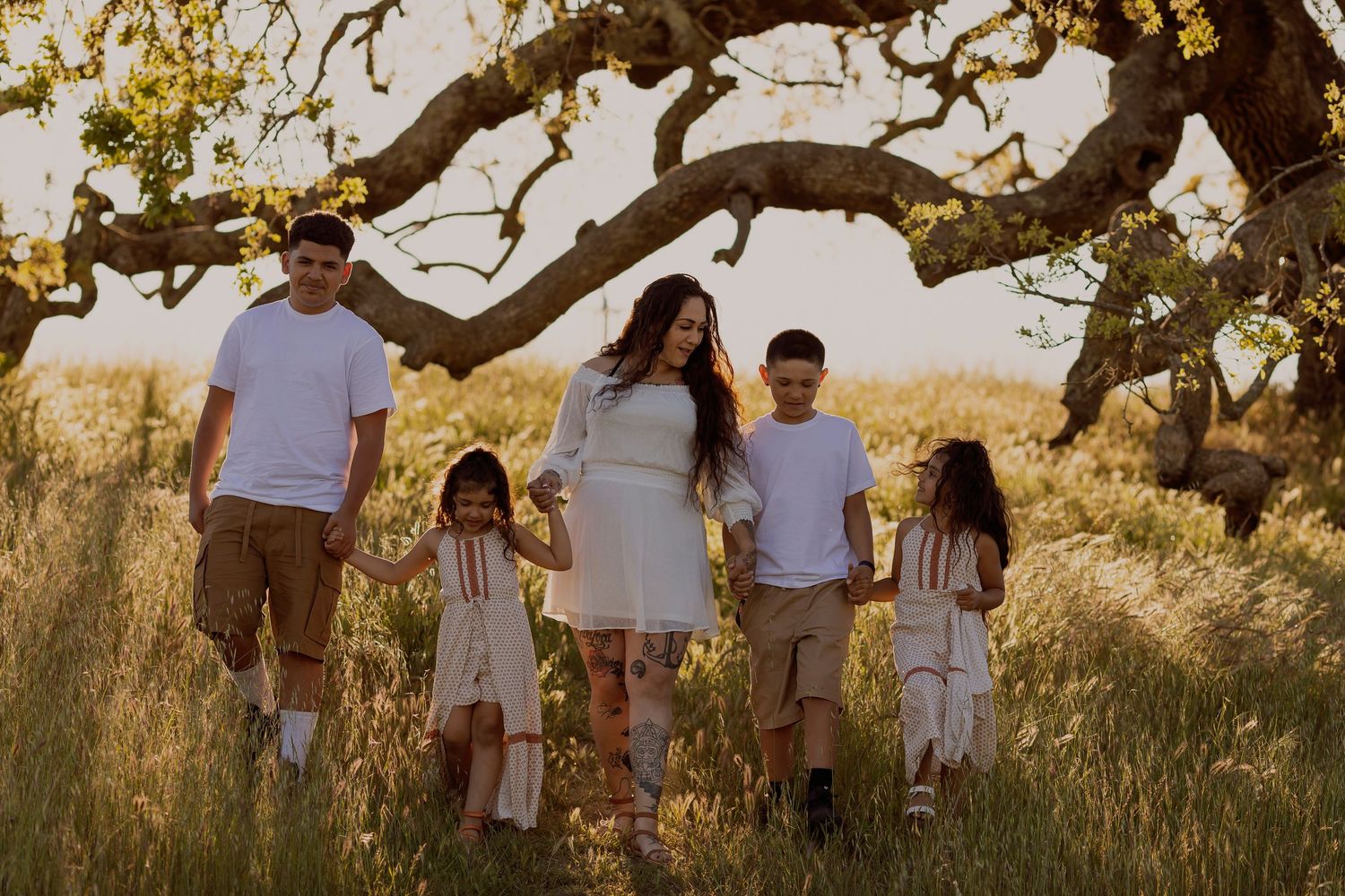 Family photography session featuring mother and children in natural golden light