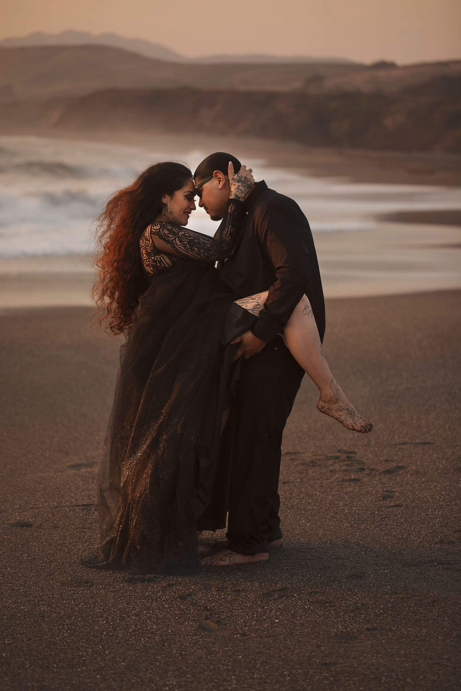 Romantic beach portrait of a couple embracing during a sunset photography session on the Bodega Bay coast.