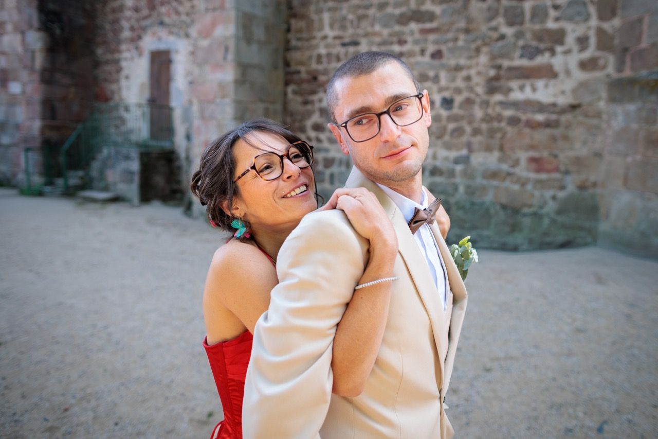 Mariée souriantes enlaçant le marié lors du shooting couple par votre photographe de mariage.