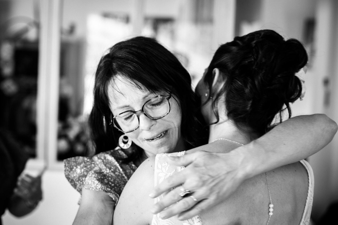 La marié et une personne proche s'enlaçant avec émotion lors d'une séance de portrait de mariage à Saint-Étienne dans la Loire.