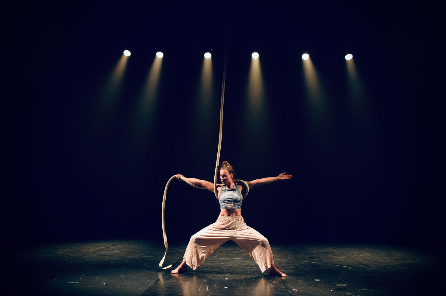 Adela Jordakova in the middle of the stage in power pose with the rope around her shoulders