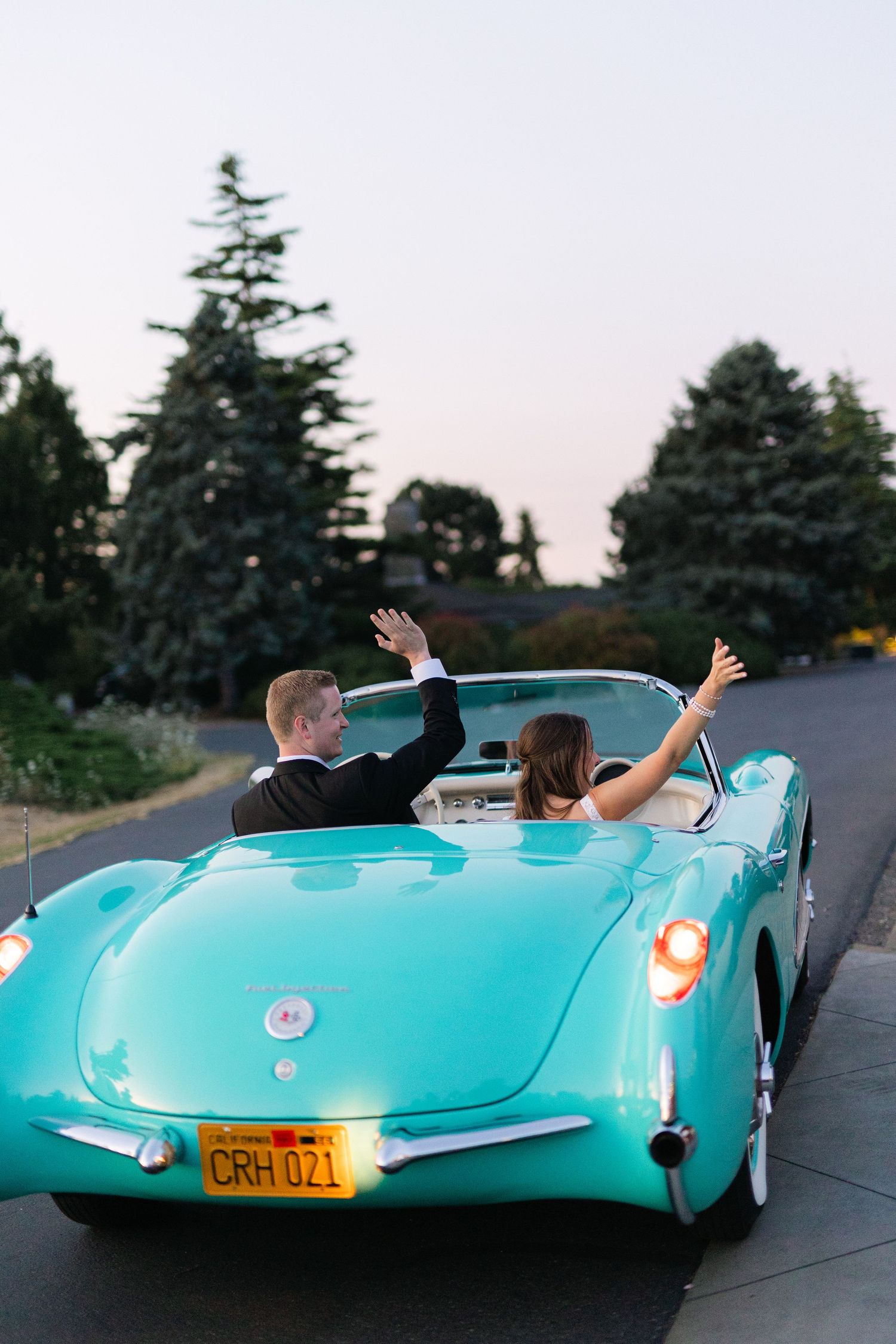A turquoise vintage custom car shown from three different angles on a street at dusk.